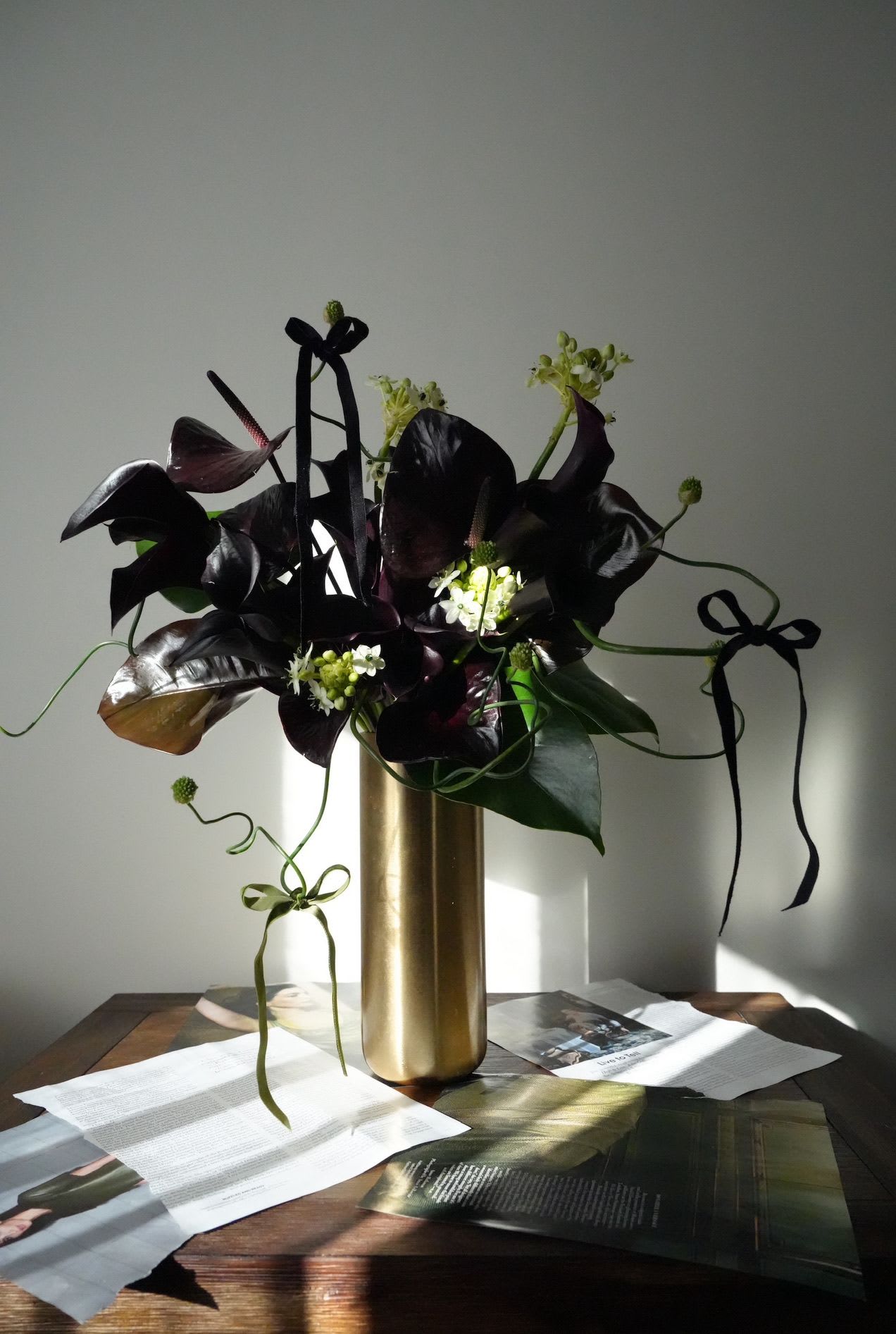 Black Ribbon - A sculptural arrangement in deep plum and black tones, accentuated with delicate greens and velvet ribbons. Bold, mysterious, and unapologetically modern.