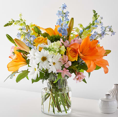 Sun Salutation Bouquet - Greet the morning with fresh yellow snapdragons, white daisies, and peach lilies to help you start the day on a sunny note. &quot;Asiatic Lilies May Come In Yellow.&quot;  19&quot;H x 19&quot;W.
