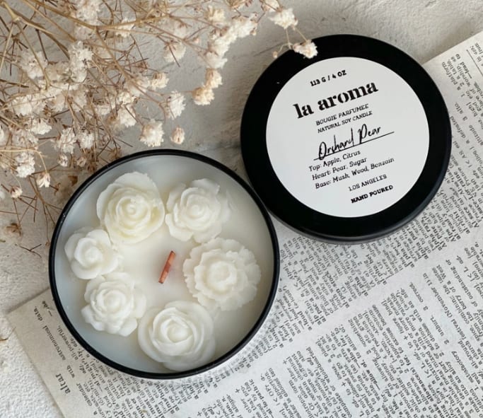 Flower Tin Candle (Wood Wick) - Gift this hand-poured 4oz soy wax candle to a best friend, mom, or girlfriend. This ready-to-gift candle is sure to brighten someone's day. These candles are hand-poured in micro-batches and decorated by hand. They are 100% vegan and made with soy wax made from American-grown soybeans.  • Metal tin size: 2.5 inches/Width 2.04 inches/Height • 4oz natural soy candle in a reusable tin with a lid • Sustainable wood wick for a clean, even burn. Creates a soothing fireplace crackle • Up to 20 hours of burn time • Hand-poured in micro-batches in Los Angeles • Fragrance depends on in-stock availability.  We advise trimming your candle wick before each use 1/4in and DO NOT leave it unattended. Store them in a cool, dry place away from sunlight or intense light.