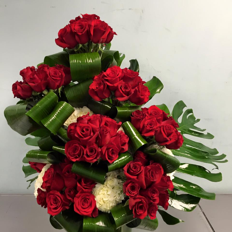 High-End Roses Bouquet - Grand sophisticated floral arrangement, which comprises of roses and Hydrangeas, 100 red roses, decorated with white Hydrangeas, aspidistra and mostera leafs.   Placed in Clear vase, decorated with tea leavers. For request can be done, with different colors. 