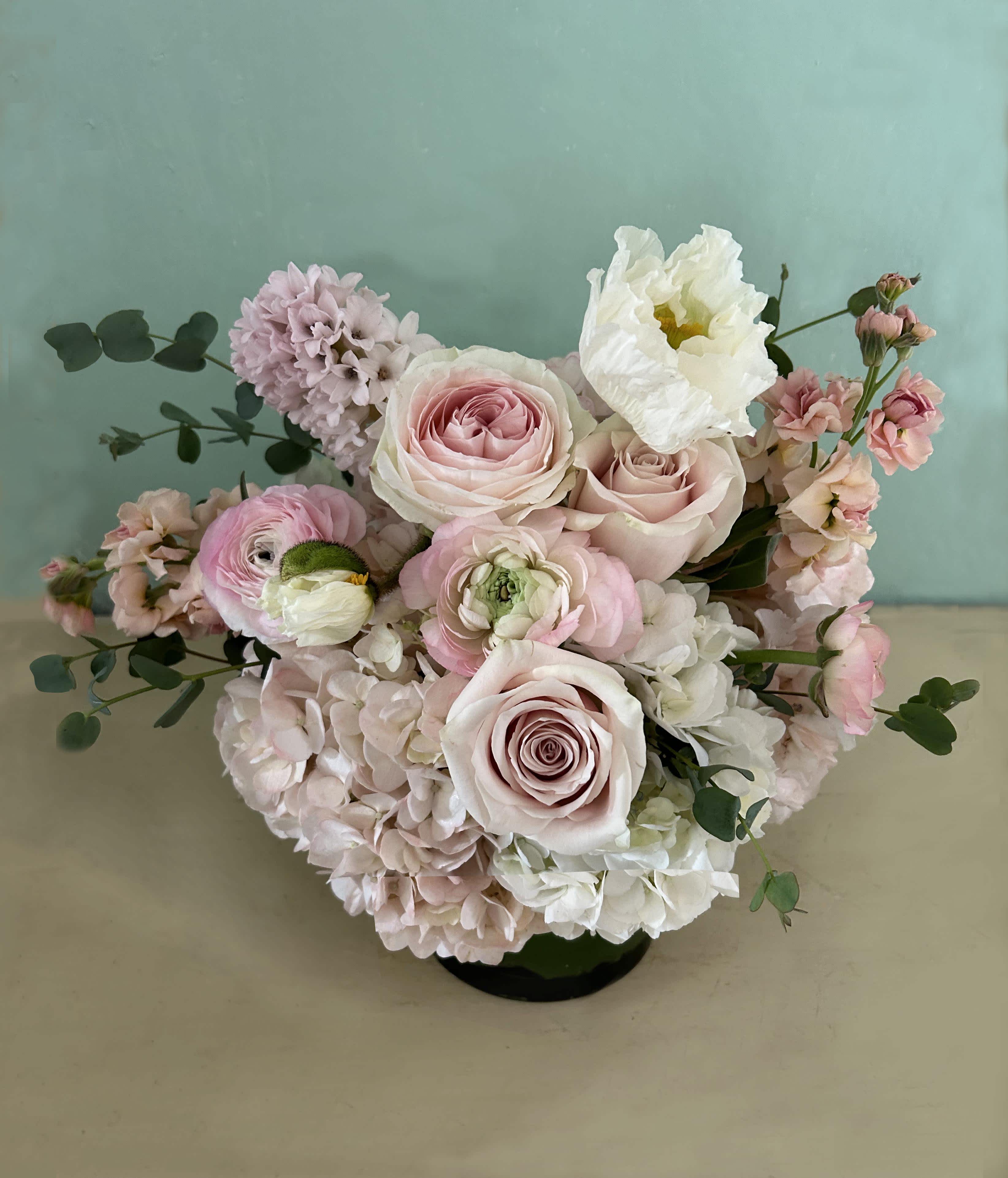 Marilyn Mini - Stunning arrangement of popular pastels like ranunculus, poppies and roses - placed in a 5&quot; by 5&quot; clear vase. Gorgeous and natural. A smaller sized arrangement, perfect if you wish to add chocolate, tea or organic beauty products at checkout. Also check the menu for &quot;Blomst Gifts&quot; and find lovely Mama friendly things to add to your most special flower delivery of the year.