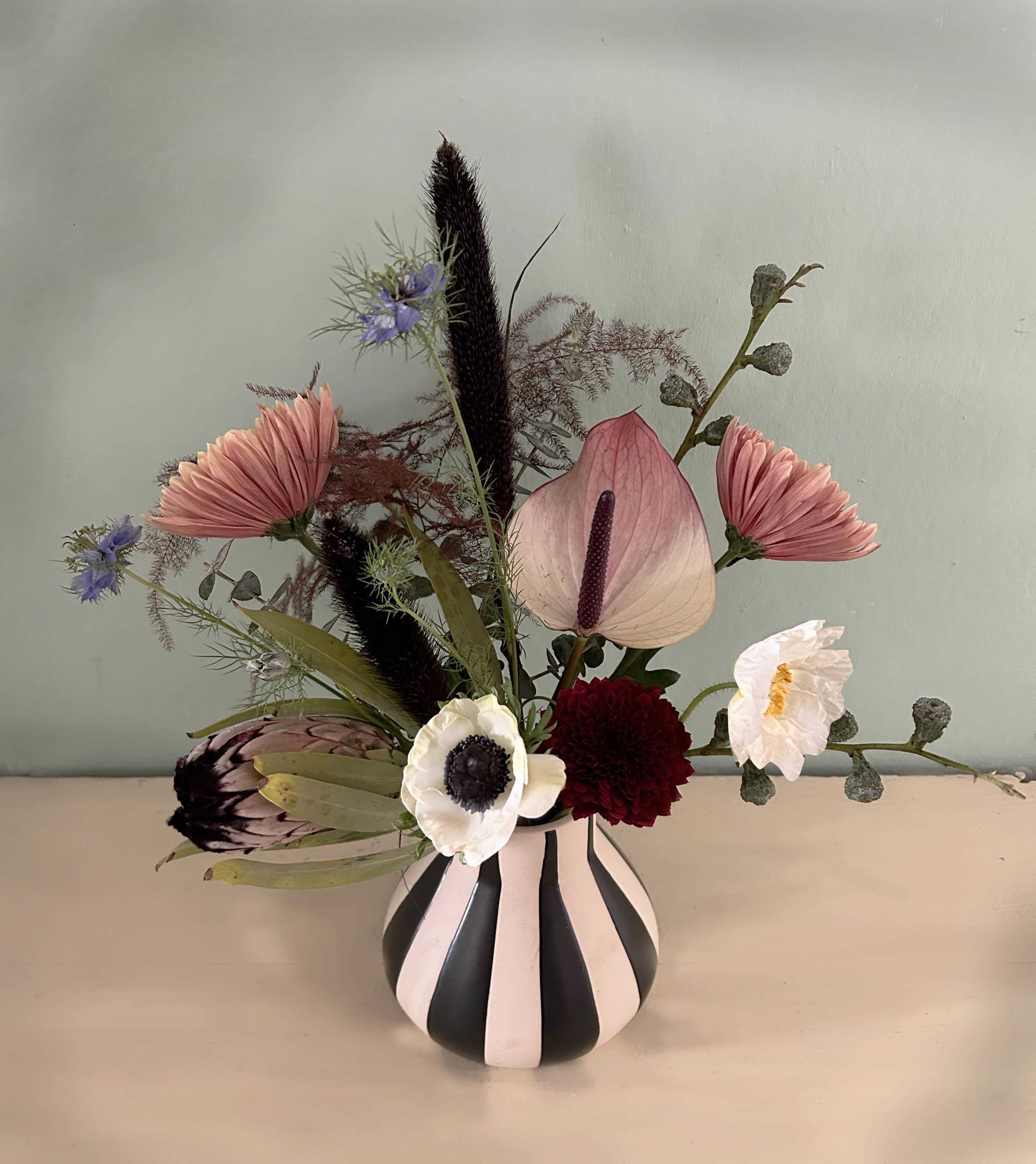 Skellington - A lovely spooky wild arrangement in a black &amp; white striped vase. Perfect for Halloween and DAy of the Dead season - available for hand delivery in LA.