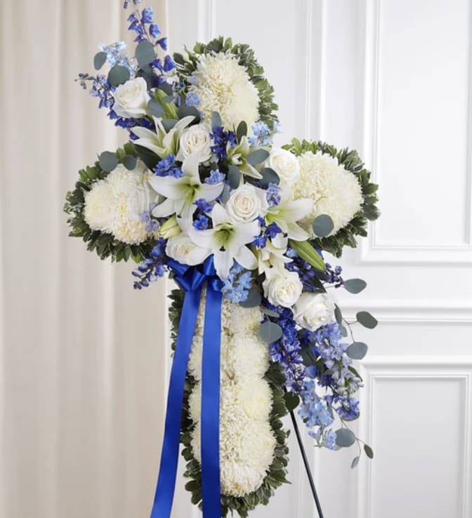 Eternal Grace - ️ Heavenly Peace – Blue &amp; White Floral Cross Tribute ️  Express love, faith, and remembrance with our Heavenly Peace Cross, a beautifully designed floral tribute featuring a cross of pure white chrysanthemums, accented with elegant white roses, lilies, and delicate blue delphiniums. Wrapped in lush greenery and finished with a deep blue satin ribbon, this standing arrangement is a heartfelt way to honor a loved one’s memory.   Why Choose This Tribute?  Premium Fresh Flowers – Handcrafted with the finest blooms  Symbol of Faith &amp; Eternal Love – A dignified tribute for memorial services  Perfect for Funerals &amp; Celebrations of Life – Offers comfort and solace to loved ones  Fast &amp; Reliable Delivery – Ensuring a seamless and respectful experience   .