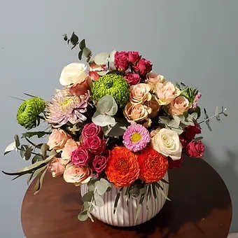 Classic Beauty arrangement - A beautiful bouquet of roses, spray roses, spider mum and eucalypus in a white vase.  