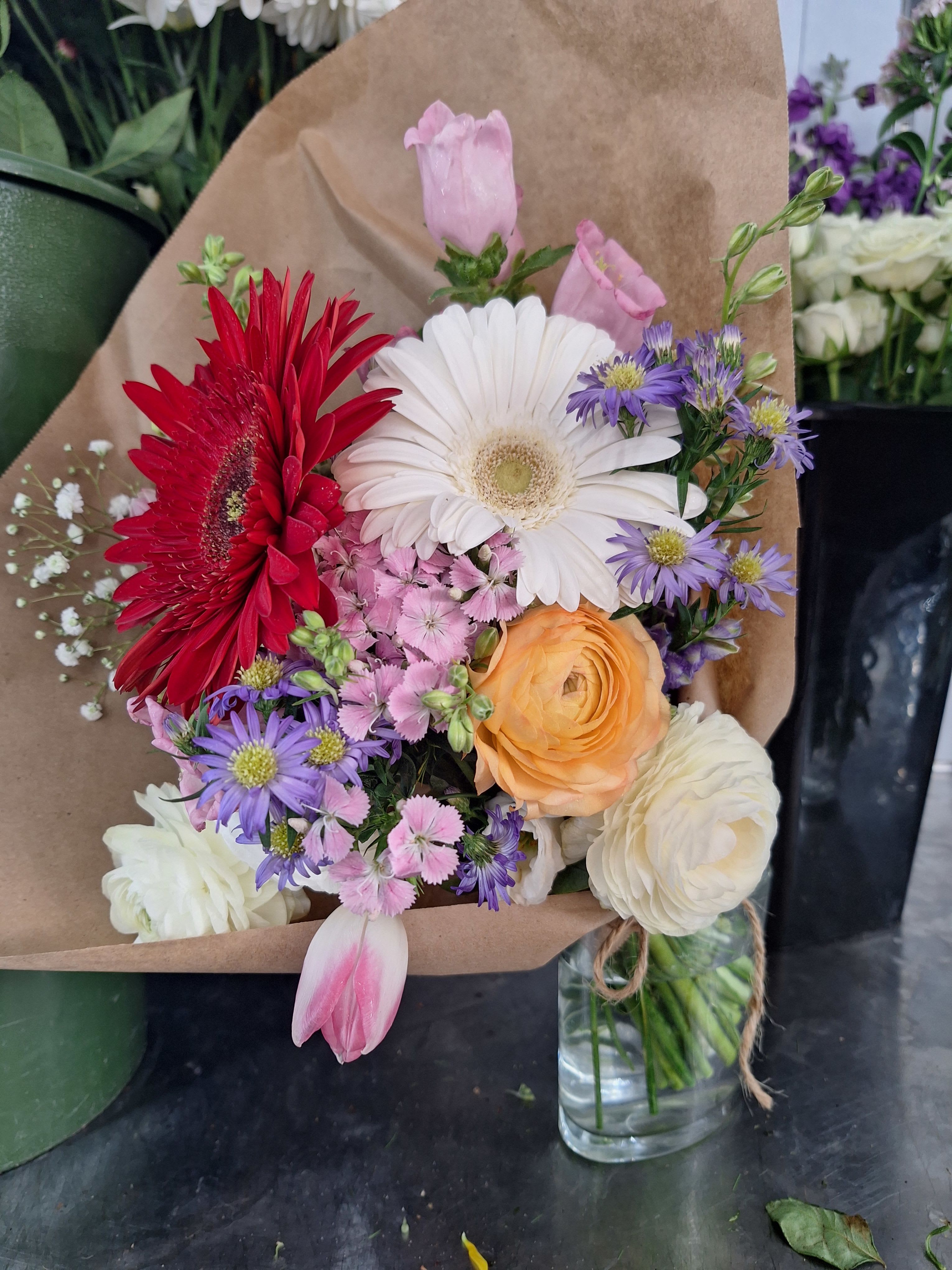 Designers Choice- All Wrapped Up - A traditional classic fresh flower wrap. This arrangement is sold WITHOUT a vase for her Favorite vase she already has at home. Get for in store Pick-up or delivery.