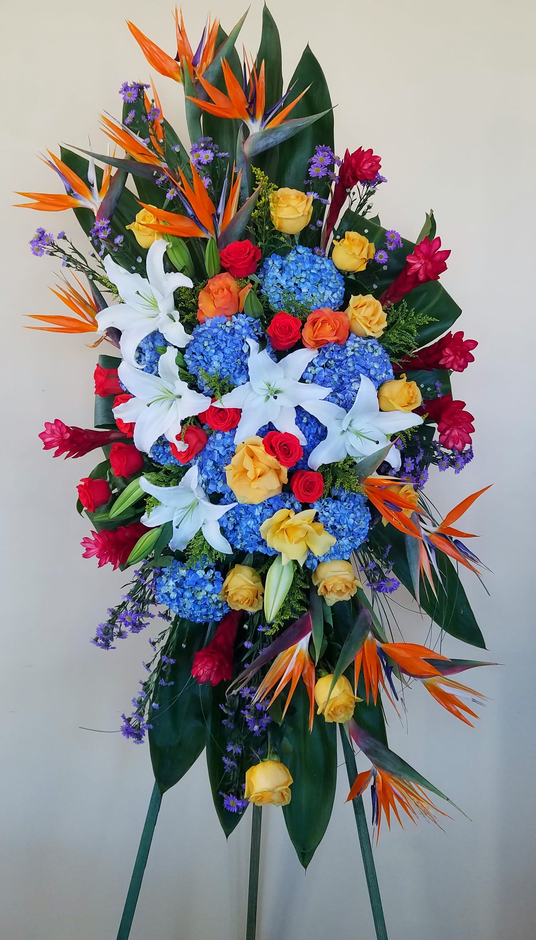 Serenity - Spray filled with hydrangeas, lilies, roses, birds of paradise, ginger, and different kinds of greenery. 7.5ft with stand and 4ft without stand