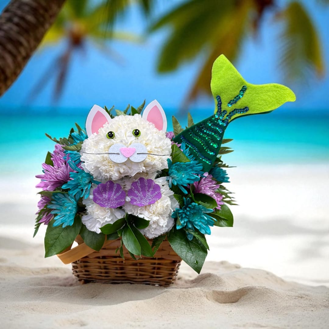 Paws in the Sand Mermaid Paws in the Sand Mermaid - Our seaside-inspired mermaid kitty is making a splash for summer! Handcrafted with white carnations, she glitters in a lavender shell top and sequined green tail. Surrounded by cool-toned blooms, this coastal cutie is ready to send waves of happiness over birthdays, beach days… any day you want to make a little more magical.
