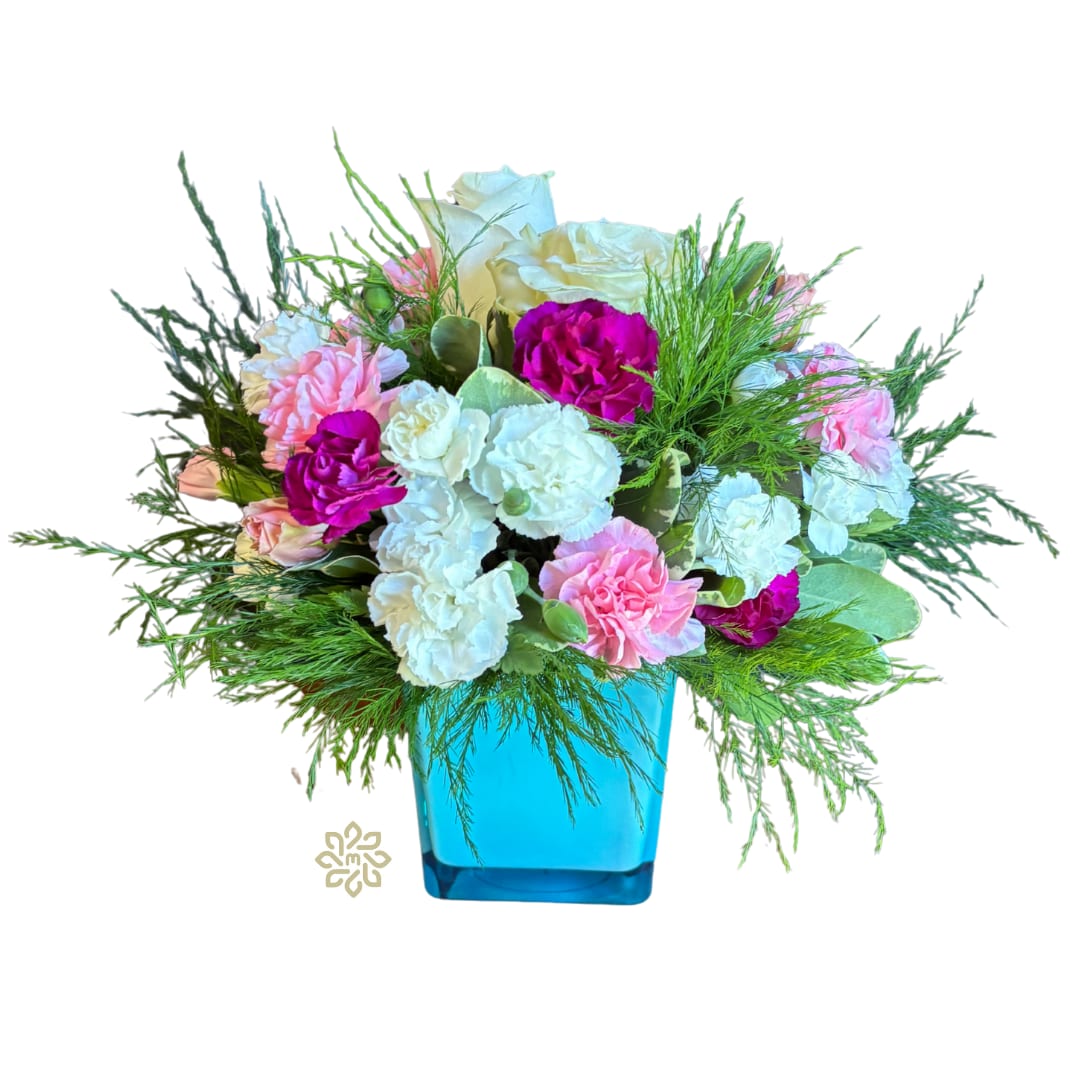 Whimsical Wonderland Cube - Welcome to a playful symphony of blooms with our Whimsical Wonderland Cube, where joy and elegance meet in a delightful dance of colors. This charming arrangement features an assortment of white and pink flowers, including classic roses and carnations, all nestled together with mini carnations for added whimsy. The bouquet is beautifully showcased in an aqua glass cube, bringing a splash of serenity and freshness to any setting.  Perfect for celebrating life's special moments or simply brightening up a loved one's day, the Whimsical Wonderland Cube is sure to bring smiles all around.