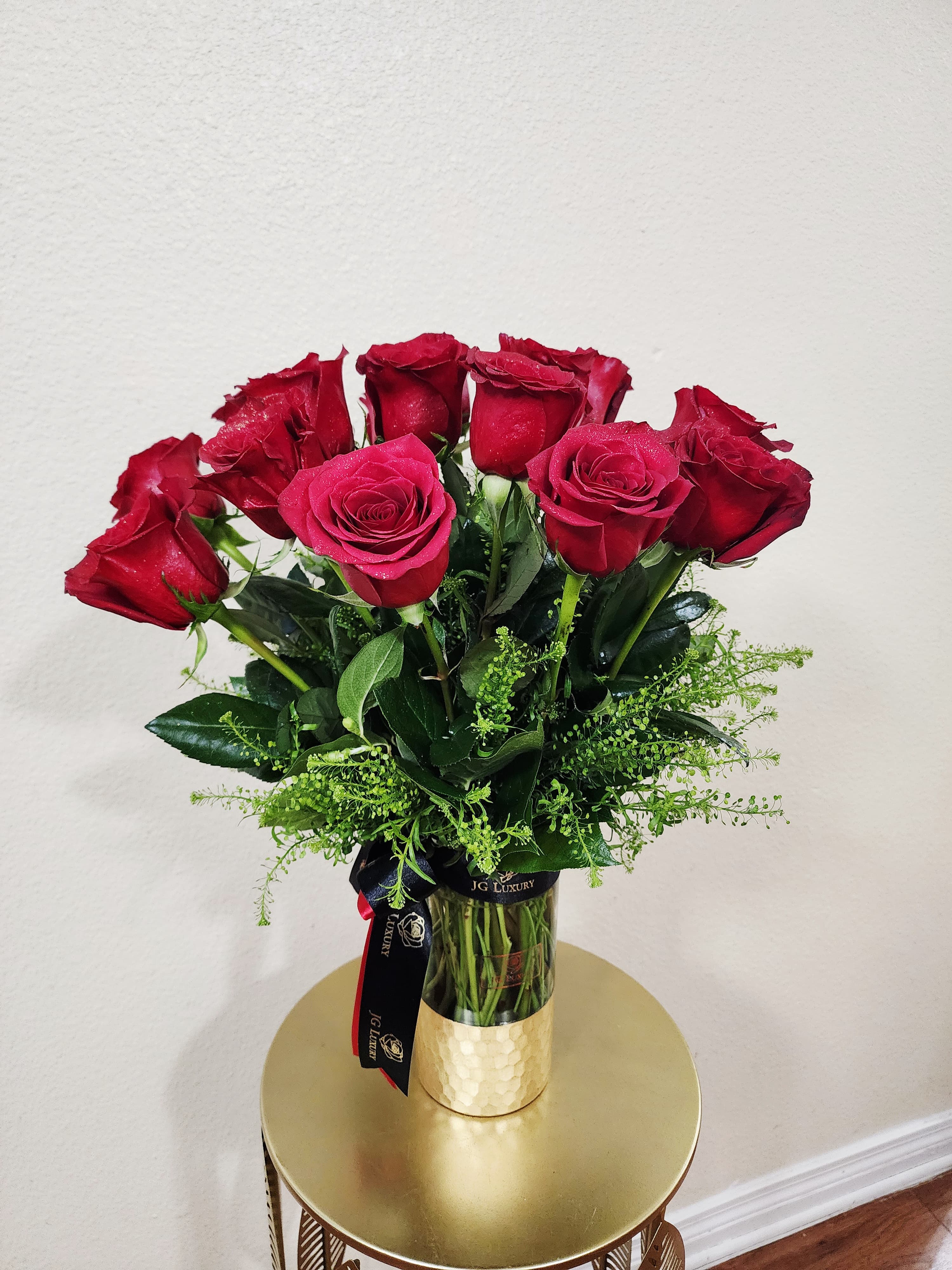 Rose Affair  - A captivating blend of passion and elegance; deep crimson roses nestled in lush greenery, arranged in a golden vase that evoques romance.