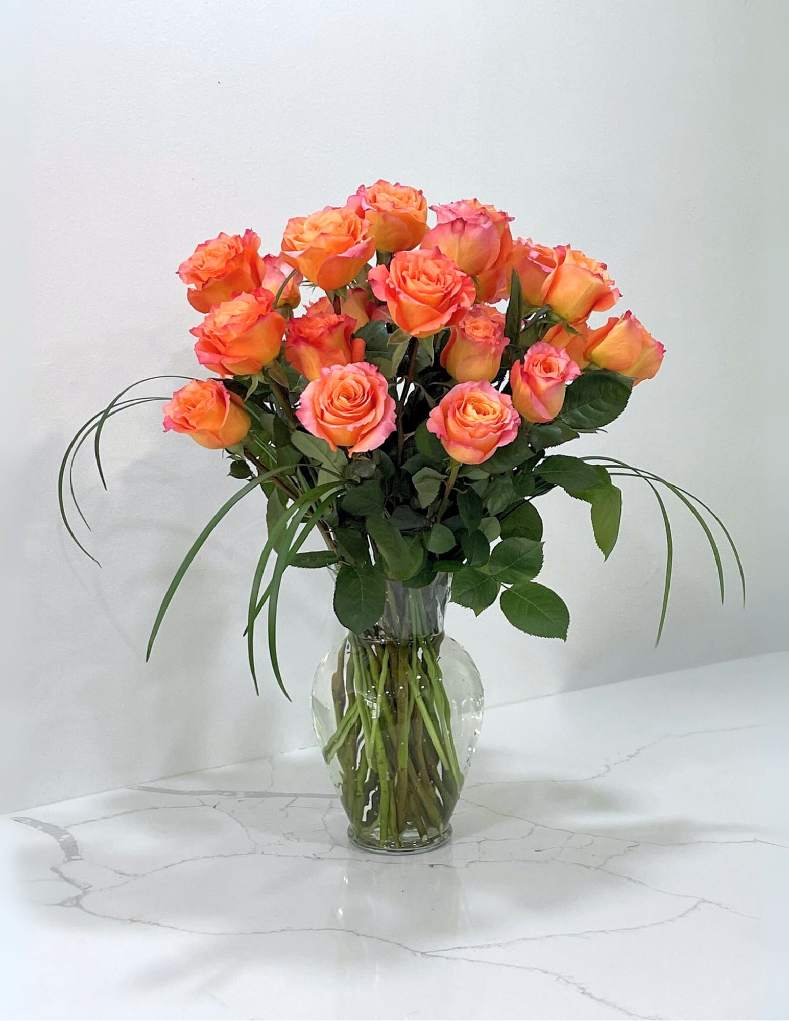 Free Spirit Free Spirit - This magnificent arrangement is all orange roses with lily grass in a clear glass vase.