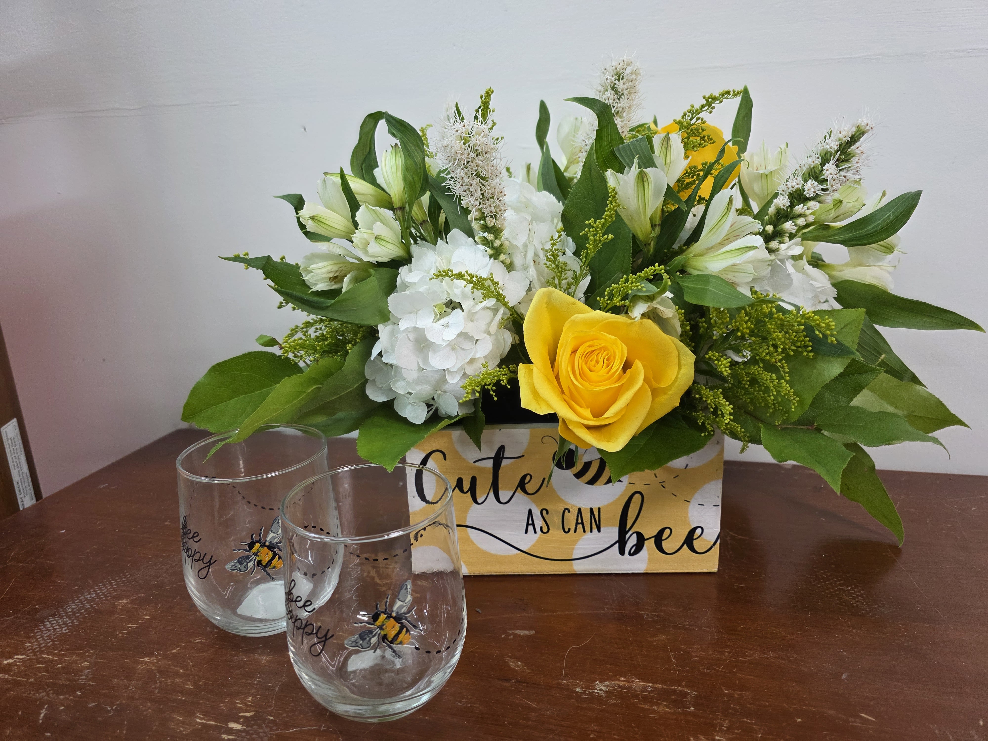 Cute as can Bee - Adorable bee box that comes filled with yellow and white blooms and two keepsake stemless wine glasses to enjoy for years to come. White hydrangeas, yellow roses, and white Alstroemeria accented with seasonal flowers makes this the perfect gift anytime and for any reason.  