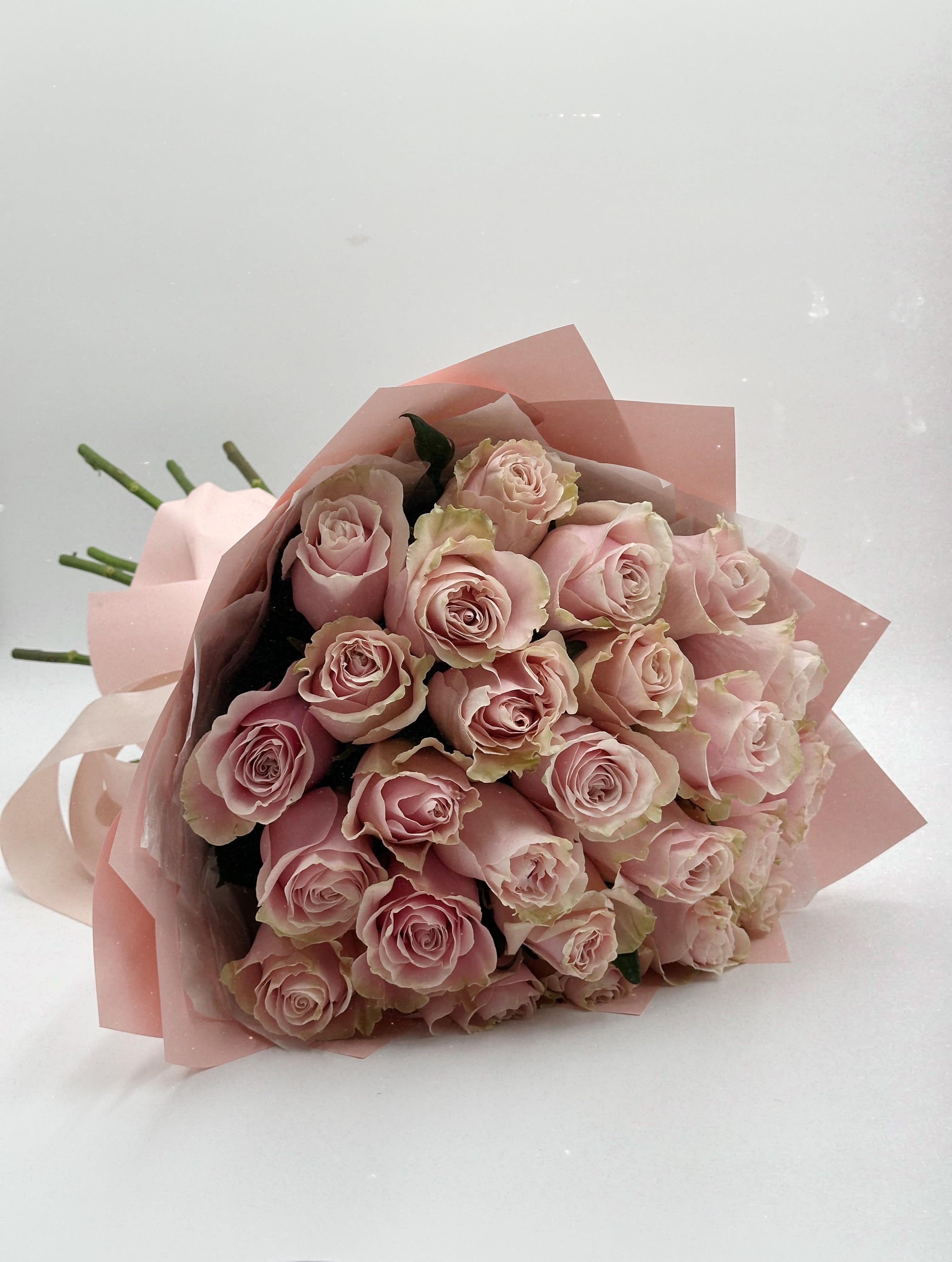 Rosy Glow Rosy Glow - A bouquet of 25 pink-and-white roses — the essence of elegance and harmony. The gentle transition from soft pink to pure white reflects tenderness, sincerity, and the warmth of a delicate touch. Wrapped in pastel-toned paper, the bouquet highlights the airy beauty of each bloom.  This arrangement speaks of care, affection, and quiet light — a perfect choice for a heartfelt gesture, a thank you, or simply to show someone they matter.
