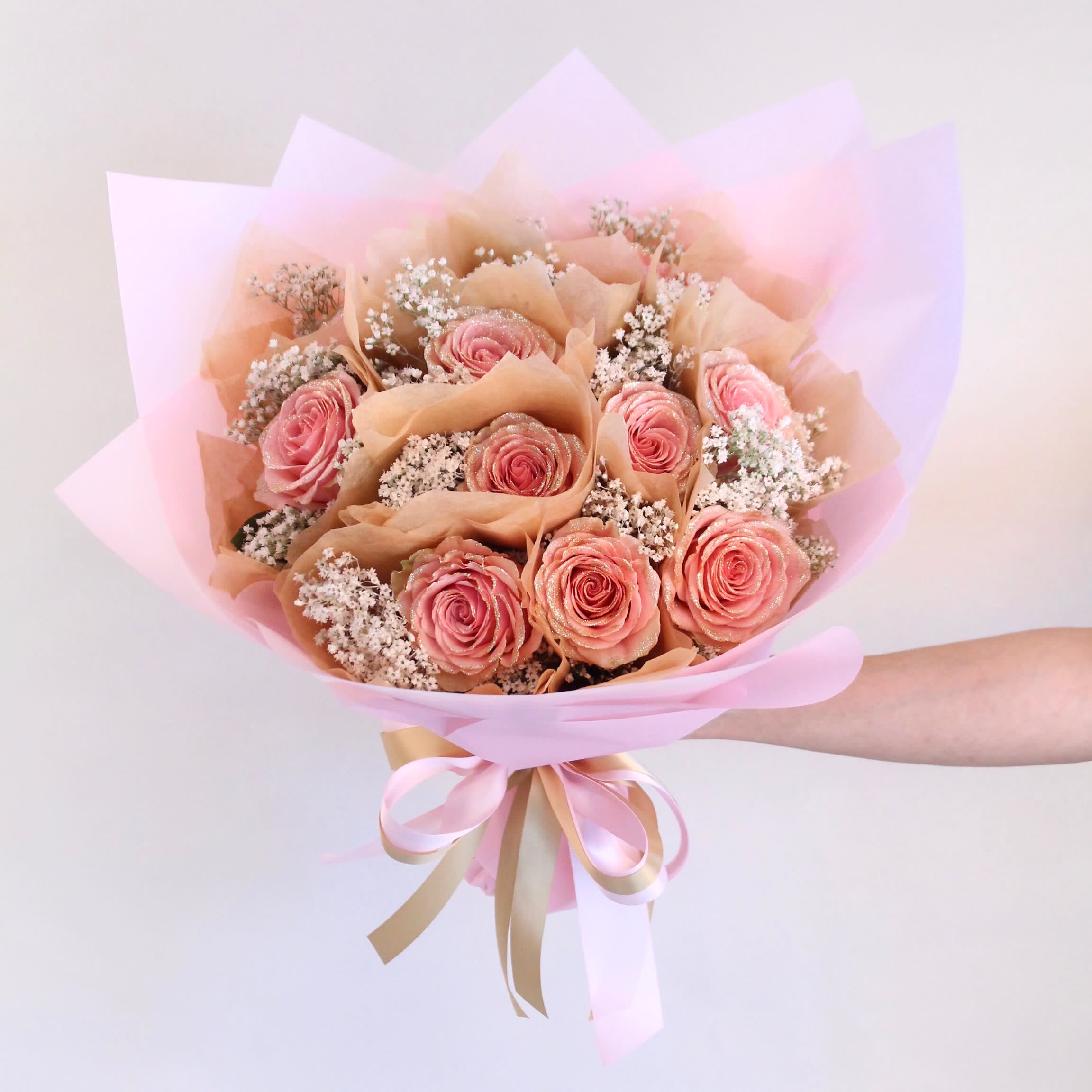 Hong Kong Roses - Glittered Roses Wrapped Hong Kong Style with Baby's Breath Hong Kong Roses - Glittered Roses Wrapped Hong Kong Style with Baby's Breath - Delight in the dazzling elegance of our Hong Kong Roses arrangement, featuring individually glittered roses wrapped meticulously in the traditional Hong Kong style. Each rose is hand-wrapped with care and accented by delicate baby’s breath, creating a luxurious bouquet that sparkles with every glance. Choose the Standard option for a beautifully wrapped bouquet, or upgrade to the Deluxe with 12 glittered roses for an even more stunning statement. Perfect for romantic occasions, anniversaries, birthdays, or any celebration where you want to impress with a unique and glamorous floral gift.