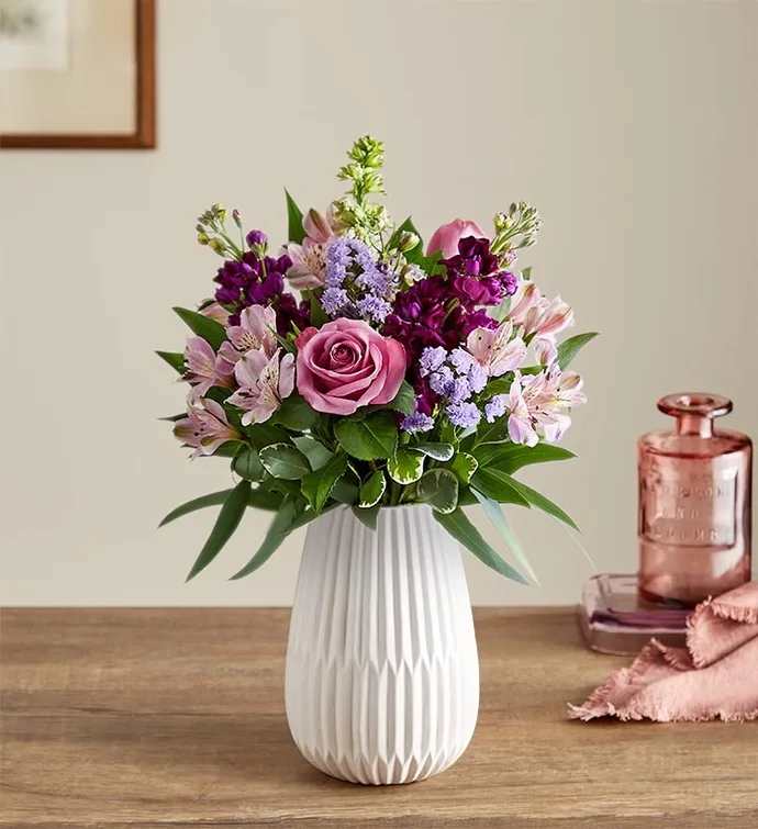 Lavender Expressions™ Bouquet By BloomNet - Send a sweet, thoughtful expression with our everyday bouquet. Hand designed by our florists, this garden-inspired gathering features soothing lavender and purple, along with accents of cascading greenery. It’s arranged in our keepsake White Modern Vase, with a tapered design and matte finish that complements the beauty of every bloom.