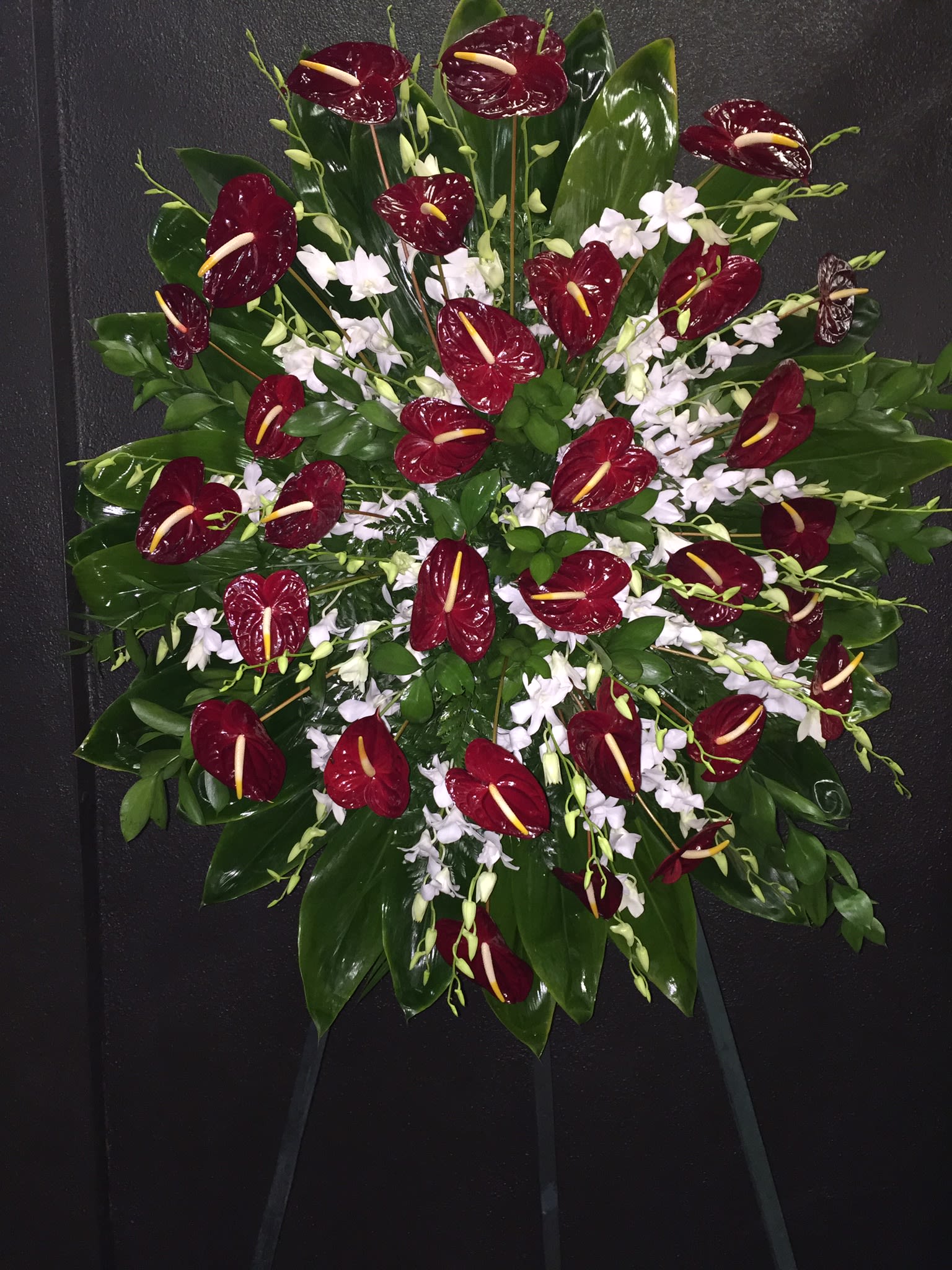Red Anthurium and White Orchid Spray Wreath - F175W02  - Red and white dramatic theme of huge red heart like antherium mixed with delicate sprays of white orchids, surrounded by lush ti leaves and other green for a tropical finish. 