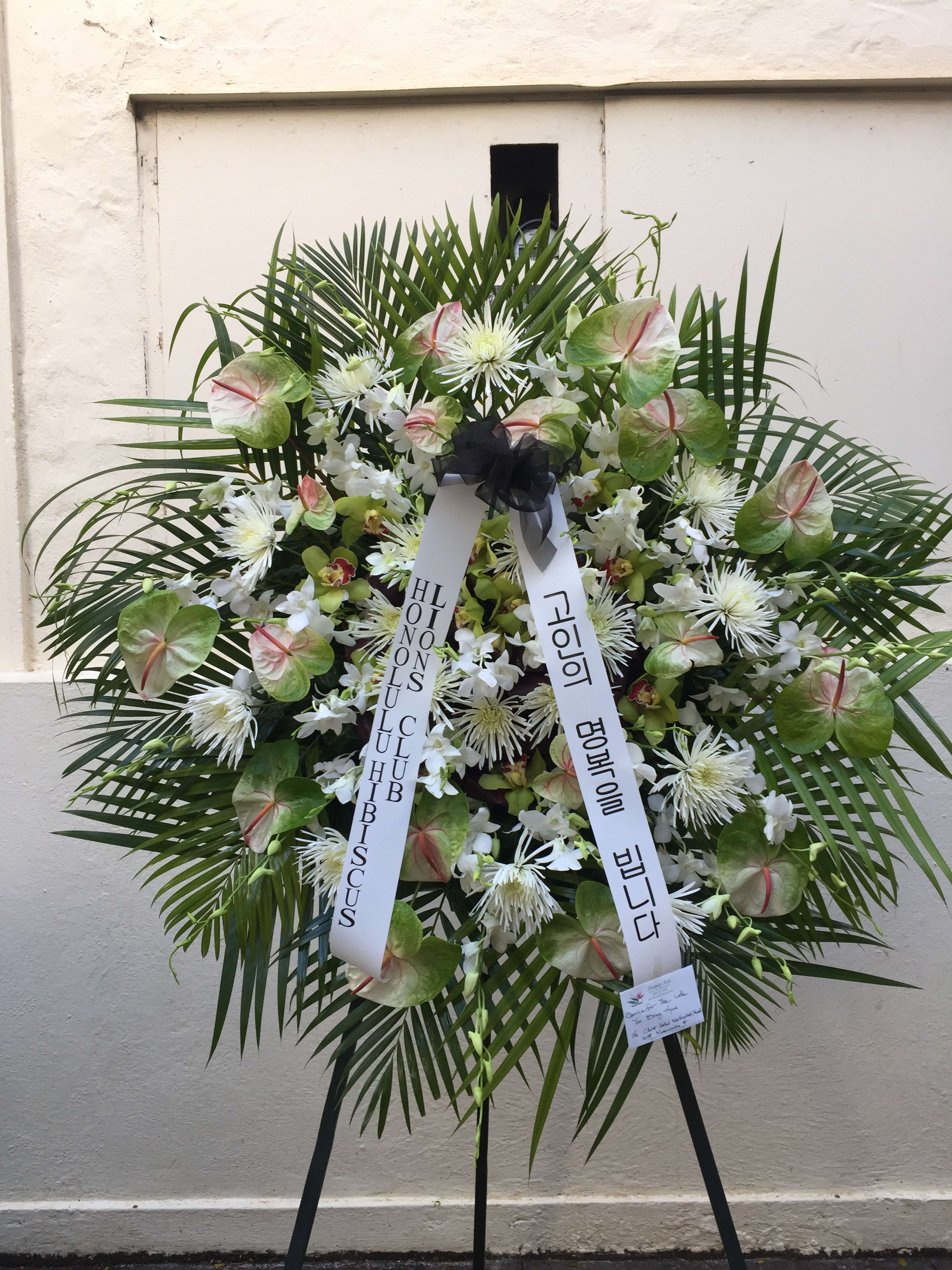 Round wreath of tropicals and chrysanthemums - F200W01 - Uniquely colorful Antherium intermingled with elegant white chrysanthemums and orchids, sunburst palm leaves surrounds 