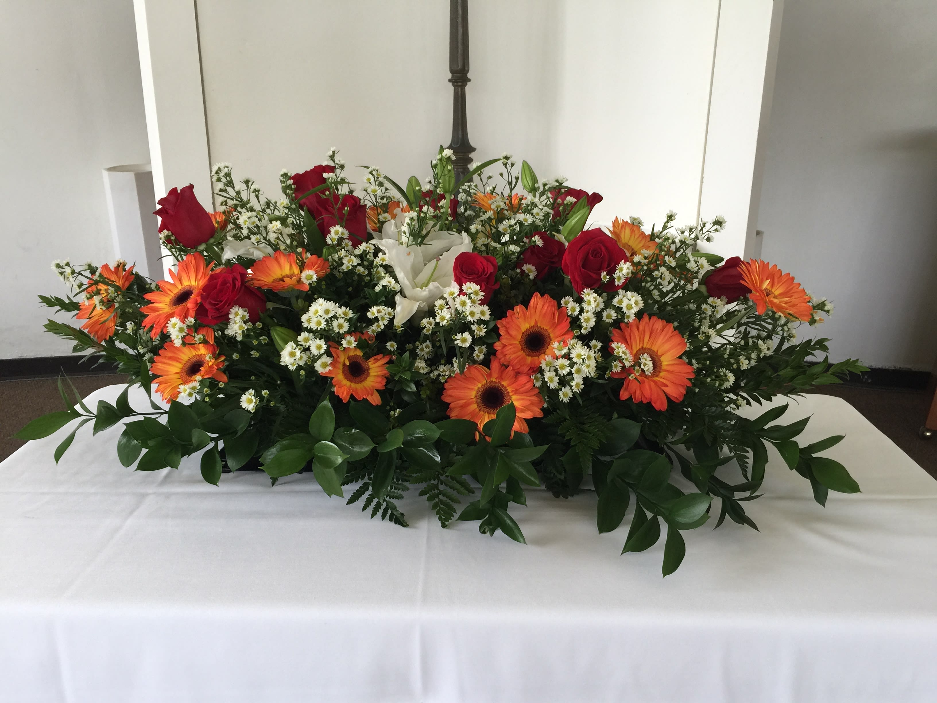 Casket arrangement of lively colorful mix blooms -  Vibrant and colorful orange Gerbera Daisies, red Roses, white Tiger lilies and other spring floral makes for a strong impact and statement