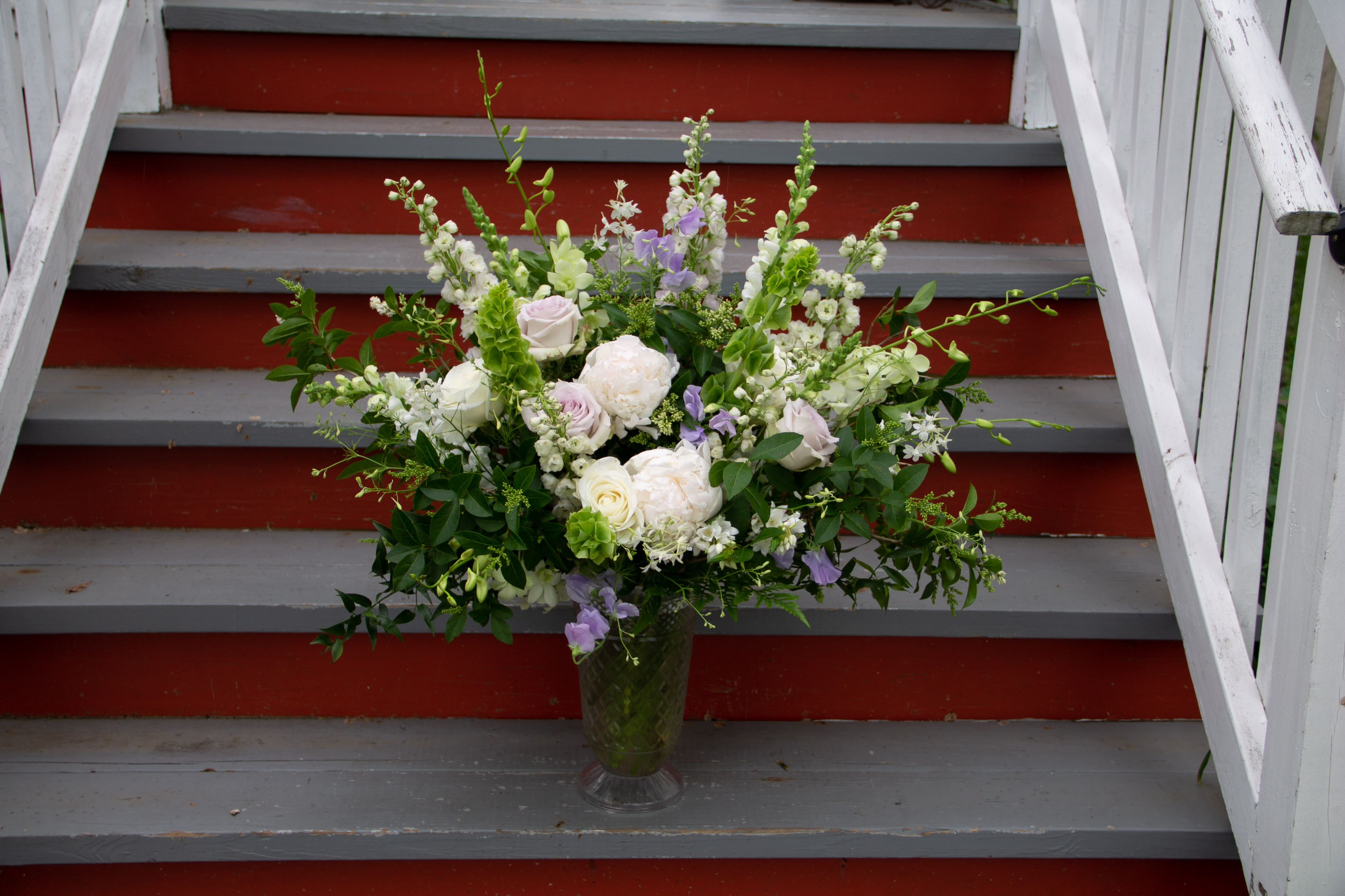 Luxury garden style sympathy arrangement - Custom - MINIMUM 48 HOURS NOTICE. Please leave a note or call us at 973-509-1999 to discuss details. We will craft for you a custom urn arrangement in an airy garden style. Full of lush greenery and premium blooms. These arrangements are meant to be a unique and special tribute to your loved one and the flowers are sourced just for you. Please let us know of any specific requests. Ordering for the service? Consider getting 2 so you can flank the casket on either side and check out our Deluxe Garden Style Casket Spray to create a full matching set. 