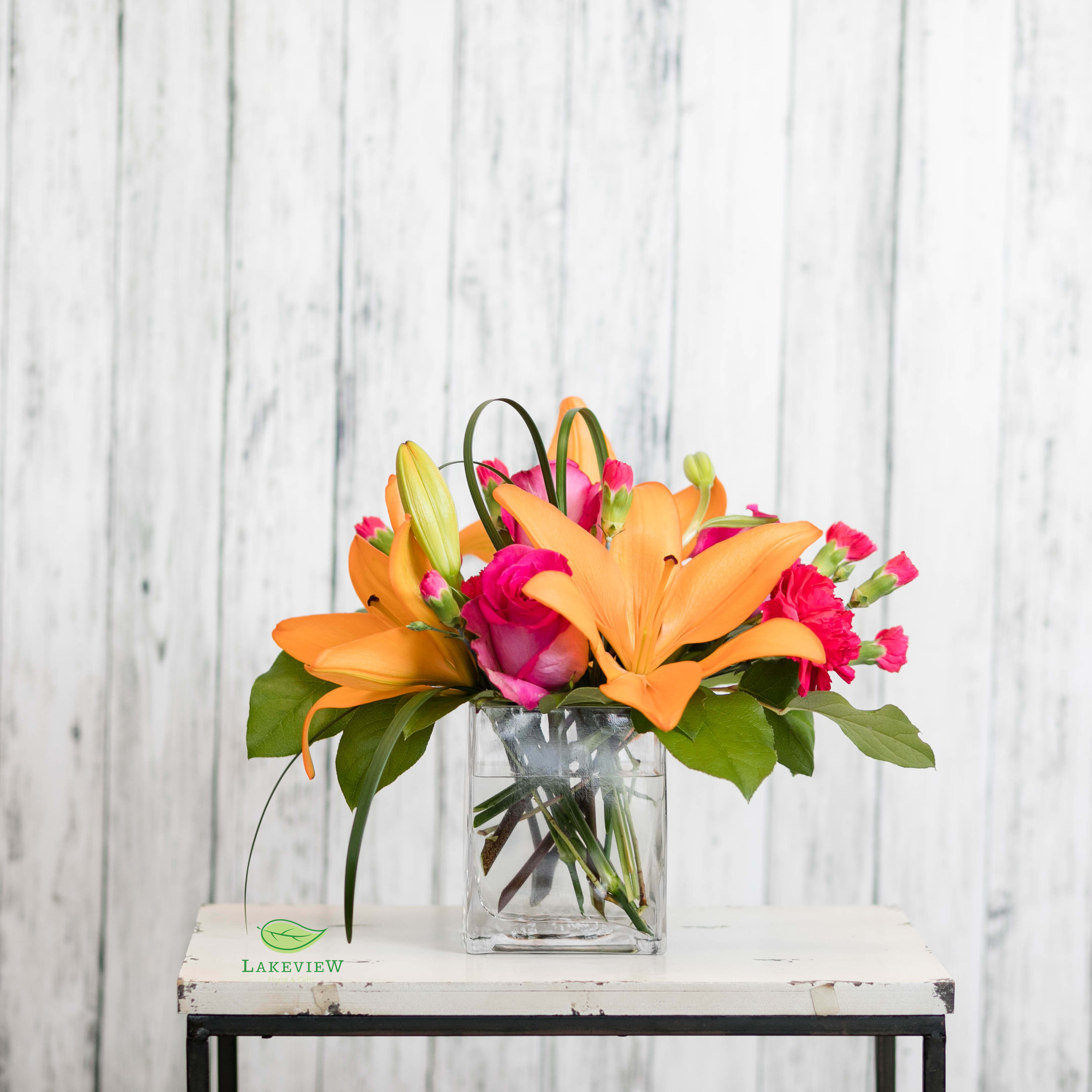 Chic - A bright combination of orange and hot pink blooms are stylishly arranged in a cube vase.  Classy &amp; bright!  Approximate Dimensions: 14&quot; H x 10&quot; W