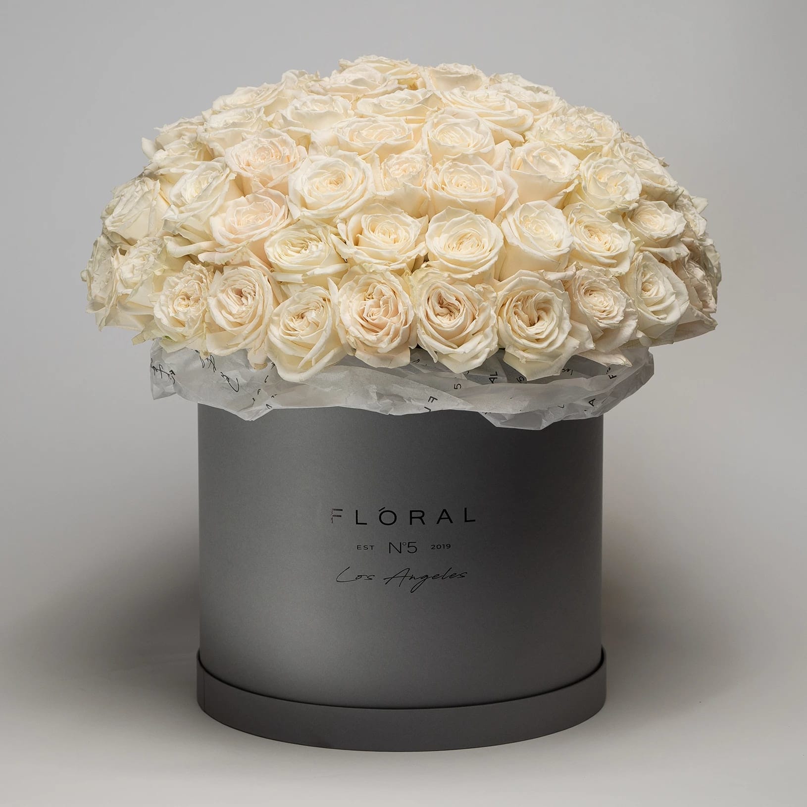 No.117 - White Roses - Expertly arranged by our skilled florist in Studio City, this box of classic roses offers a modern twist on a timeless gesture. Elegant and refined, it's the perfect gift for any occasion. With same day flower delivery available, sending a stunning floral surprise has never been easier. Experience the beauty and sophistication of a luxurious rose presentation.  Standard box made with 50 white roses. Deluxe box made with 75 white roses.  Premium box made with 150 white roses.   On the photo: Size - Deluxe, Box Material - Paper, Box Color - Grey.