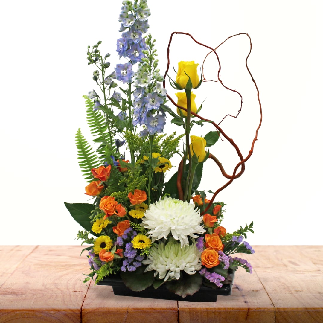 Gleeful Gardens of Summer (Design Winner) - Introducing a stunning creation by our first design contest winner! This beautiful arrangement features an assortment of popular garden-style flowers arranged in a contemporary design, bringing a fresh and exciting touch to any space.  Key Features:  Award-Winning Design: Created by the winner of our inaugural design contest, this arrangement showcases exceptional creativity and style.  Assortment of Garden Flowers: Featuring a delightful mix of popular garden-style flowers, this piece brings the natural beauty of a garden indoors.  Contemporary Flair: Arranged with a modern and artistic touch, this design adds a contemporary flair to any room, making it a perfect centerpiece.  Versatile Decor: Ideal for any occasion, from celebrations to everyday enjoyment, this arrangement adds excitement and elegance to any setting. Celebrate the artistry and beauty of our Award-Winning Contemporary Garden Style Arrangement, and bring a touch of garden charm to your home or office.       