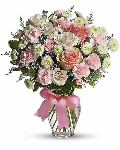 Cotton Candy - What a sweet way to celebrate the arrival of sugar and spice and everything nice! This pretty arrangement will delight any new mom or mom-to-be, that's for sure! Feminine flowers fill a charming ribbon-wrapped vase. It's a beautiful thing!  Pretty pink roses, spray roses and miniature carnations, white button spray chrysanthemums, lavender limonium and green pittosporum fill a spring glass vase that's wrapped with a pink satin ribbon. It's confection perfection!
