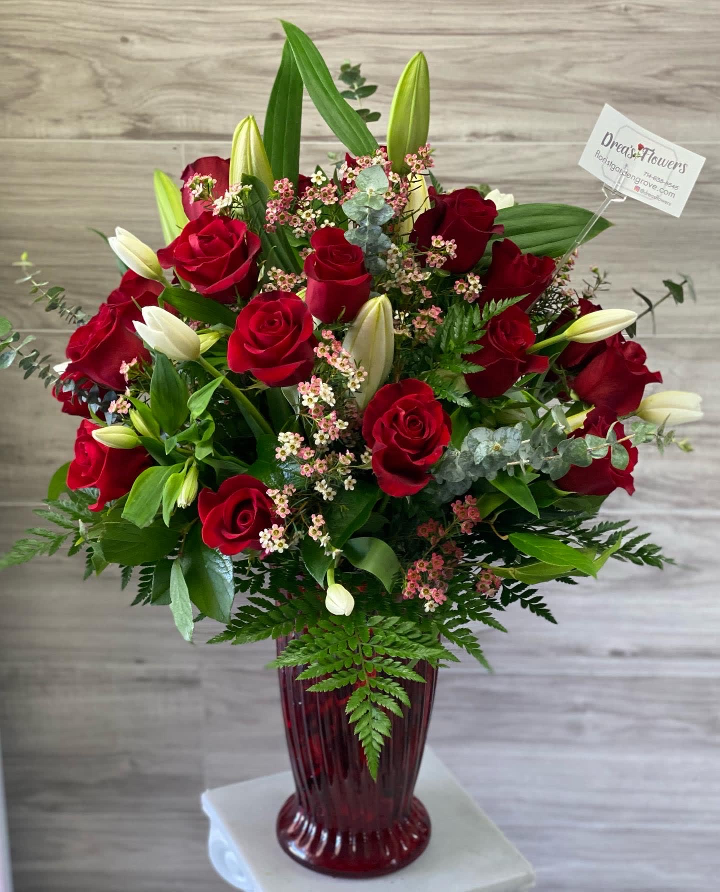 Out of the dog house Out of the dog house - long stem red roses , white tulips, white lilies, wax and Eucalyptus.
