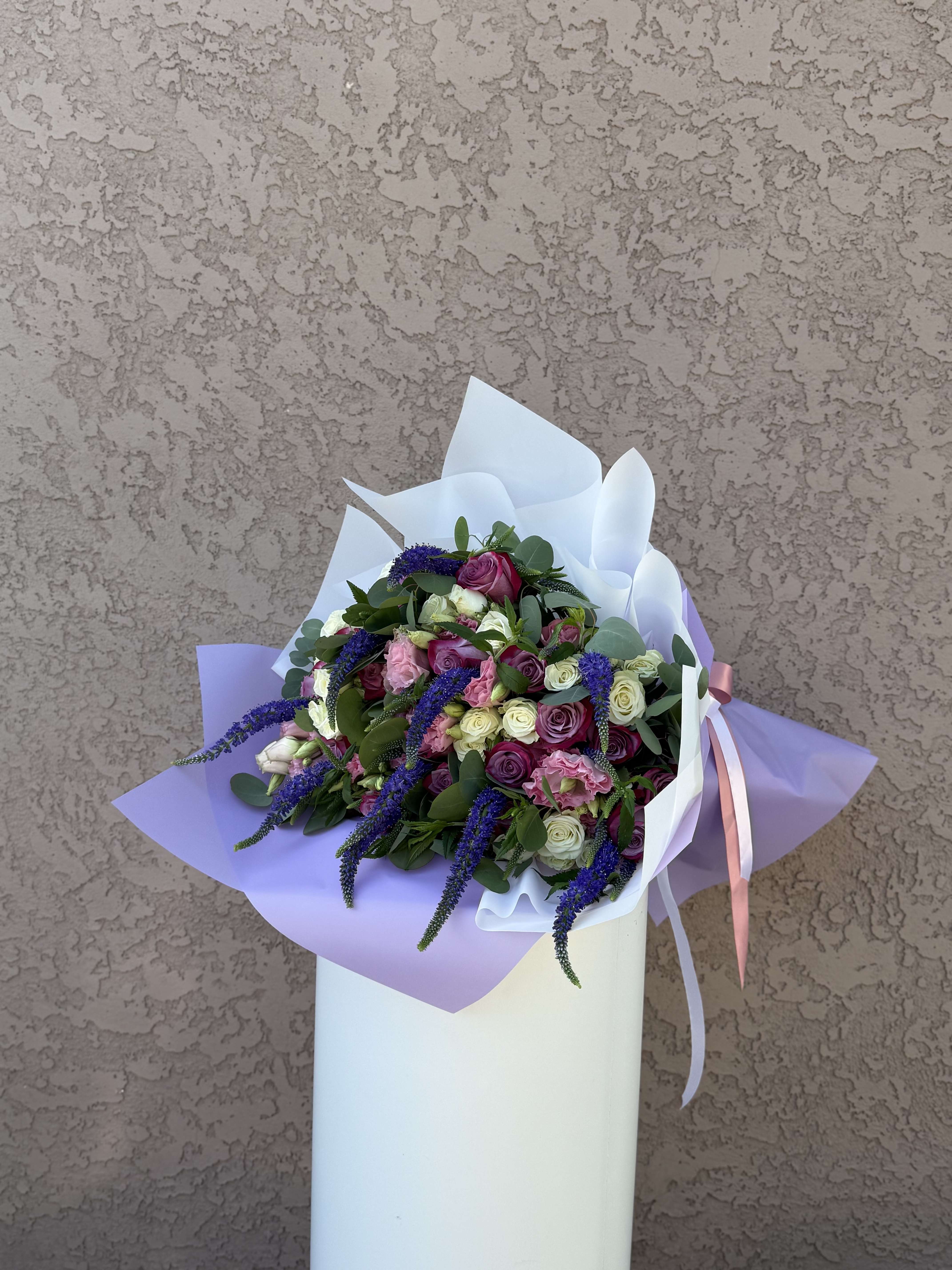 Lavender Muse - Softly poetic and effortlessly elegant, Lavender Muse features a dreamy mix of lavender, blush, and cream roses accented by cascading veronica and eucalyptus. Wrapped in lilac and ivory with a satin blush ribbon, this hand-tied bouquet is designed in Beverly Hills, CA and available for delivery throughout Los Angeles. A perfect choice for birthdays, romance, or creative souls, this bouquet is handcrafted by Family Tree Flower — your go-to Beverly Hills florist for luxury floral design and same-day delivery across LA.  Roses – Enchantment, love at first sight, elegance. Spray Roses – Grace, charm, and sincerity. Pink Lisianthus – Admiration, tenderness, and thoughtfulness. Purple Veronica – Intuition, transformation, and fidelity.