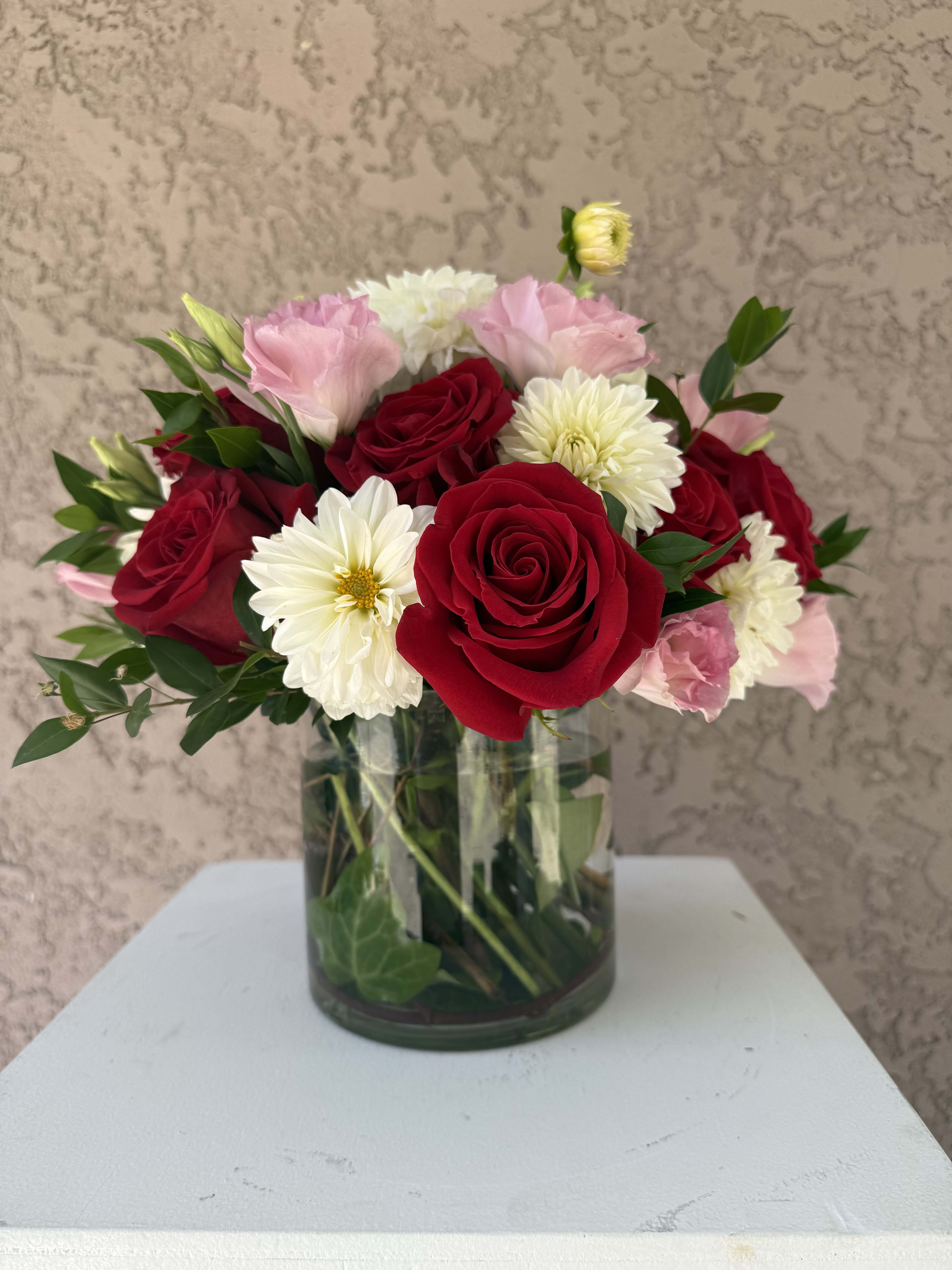 Love Notes - Soft and romantic with a bold twist, Love Notes blends red roses, pink lisianthus, creamy white mums, and fresh greenery in a clear vase. Designed in Beverly Hills, CA and available for delivery throughout Los Angeles, this arrangement is perfect for anniversaries, birthdays, or sending heartfelt affection. Created with care by Family Tree Flower, your local Beverly Hills florist offering luxury flowers and same-day delivery across the LA area.  Red Roses – Passion, love, and deep emotion. Pink Lisianthus – Grace, charm, and appreciation. White Chrysanthemums (Mums) – Loyalty, truth, and sincerity.