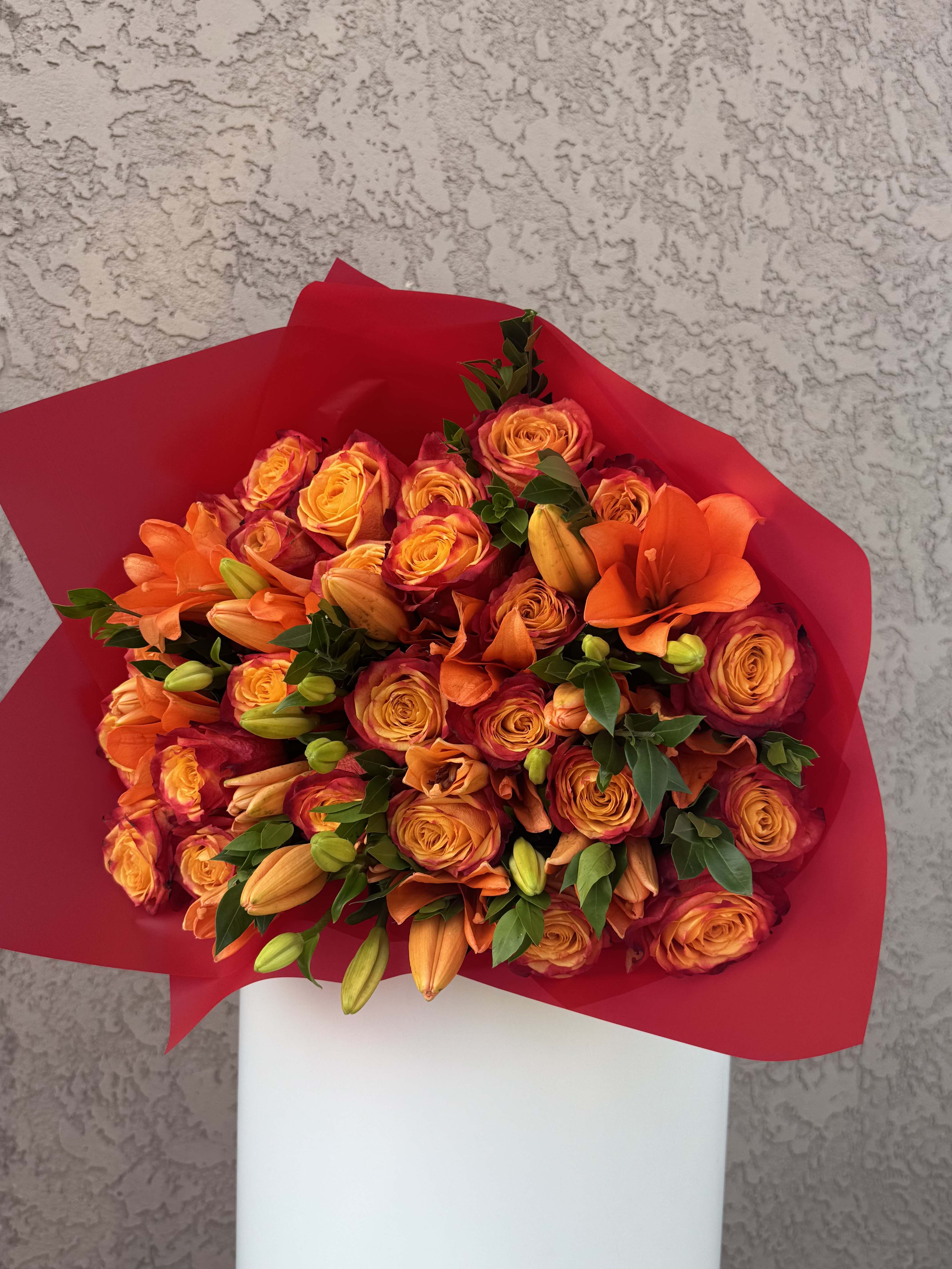Tangerine Flame - Bursting with bold personality, Tangerine Flame features a vibrant hand-tied mix of orange lilies and fiery bi-color roses wrapped in vivid red and tied with a bright orange satin ribbon. Handcrafted in Beverly Hills, CA and available for delivery throughout Los Angeles, this bouquet is perfect for birthdays, congratulations, or anyone who loves color and confidence. Designed with passion by Family Tree Flower — your local Beverly Hills florist offering same-day delivery across the LA area.  Orange Lilies – Passion, warmth, and confidence. Orange-Red Bi-Color Roses – Admiration, creativity, and enthusiasm.