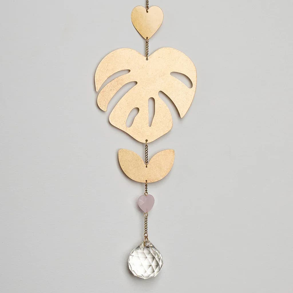 Suncatcher - Monstera Leaf / Rose Quartz - Suncatcher - Monstera Leaf / Rose Quartz Stone of the Heart - Materials: Brass with gold plating, crystal, semi-precious stone and suction cup with a metal hook. Indoor use only. CA005