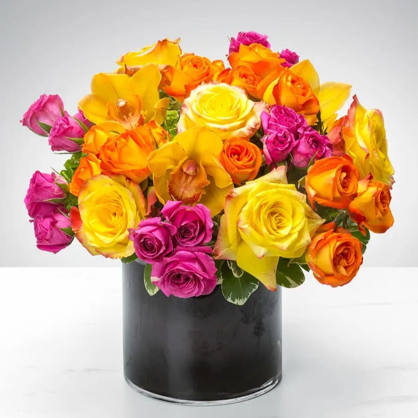 Bright Abundance  - Elevate any occasion with this vibrant and sophisticated arrangement featuring the perfect blend of golden yellows, warm oranges and soft pink orchids, roses and spray roses on a bed of fine greenery arranged in a keepsake cylinder vase. Perfect gift to welcome home, a newly opened business, a thank you and get well.  Order for same day delivery today!  Approximately 10&quot; D