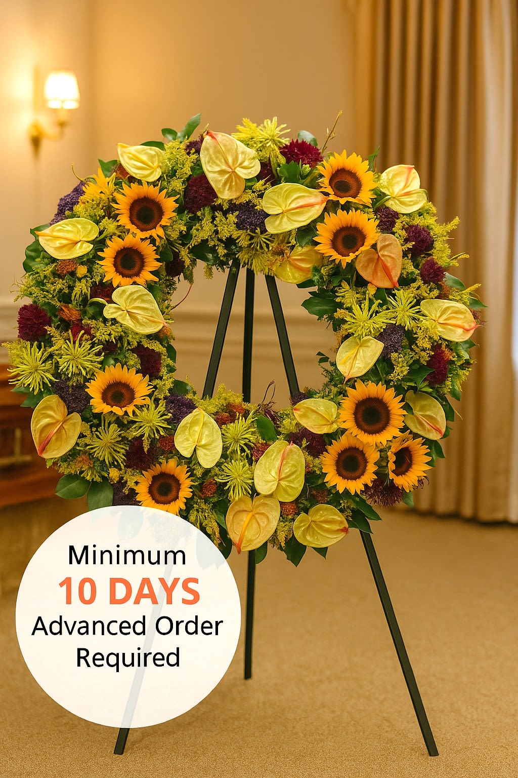 Watanabe Tropical Sunset Wreath - Honor the memory of a loved one with this beautiful wreath made out of sunflowers, symbolizing the wonderful memories of the deceased. Standing approximately 30&quot; wide and presented on a 6' easel, this arrangement offers a grand and heartfelt tribute. Please note that a minimum days' advanced notice is required to ensure the flowers can be properly staged for quality results.  Key Features:  Stunning Dimensions: Stands approximately 30&quot; wide, creating an impressive and elegant display.  High-Quality Arrangement: Expertly crafted with vibrant sunflowers, symbolizing joy and cherished memories, to ensure lasting beauty and impact.  Elegant Presentation: Mounted on a 6' easel, making it perfect for memorials, celebrations of life, or any event where a beautiful tribute is desired.  Meaningful Tribute: Designed to honor and celebrate the life of a loved one with grace and elegance.  Celebrate and honor the memory of a loved one with our Sunflower Remembrance Wreath, a beautiful and meaningful tribute that reflects the joy and cherished memories they left behind.