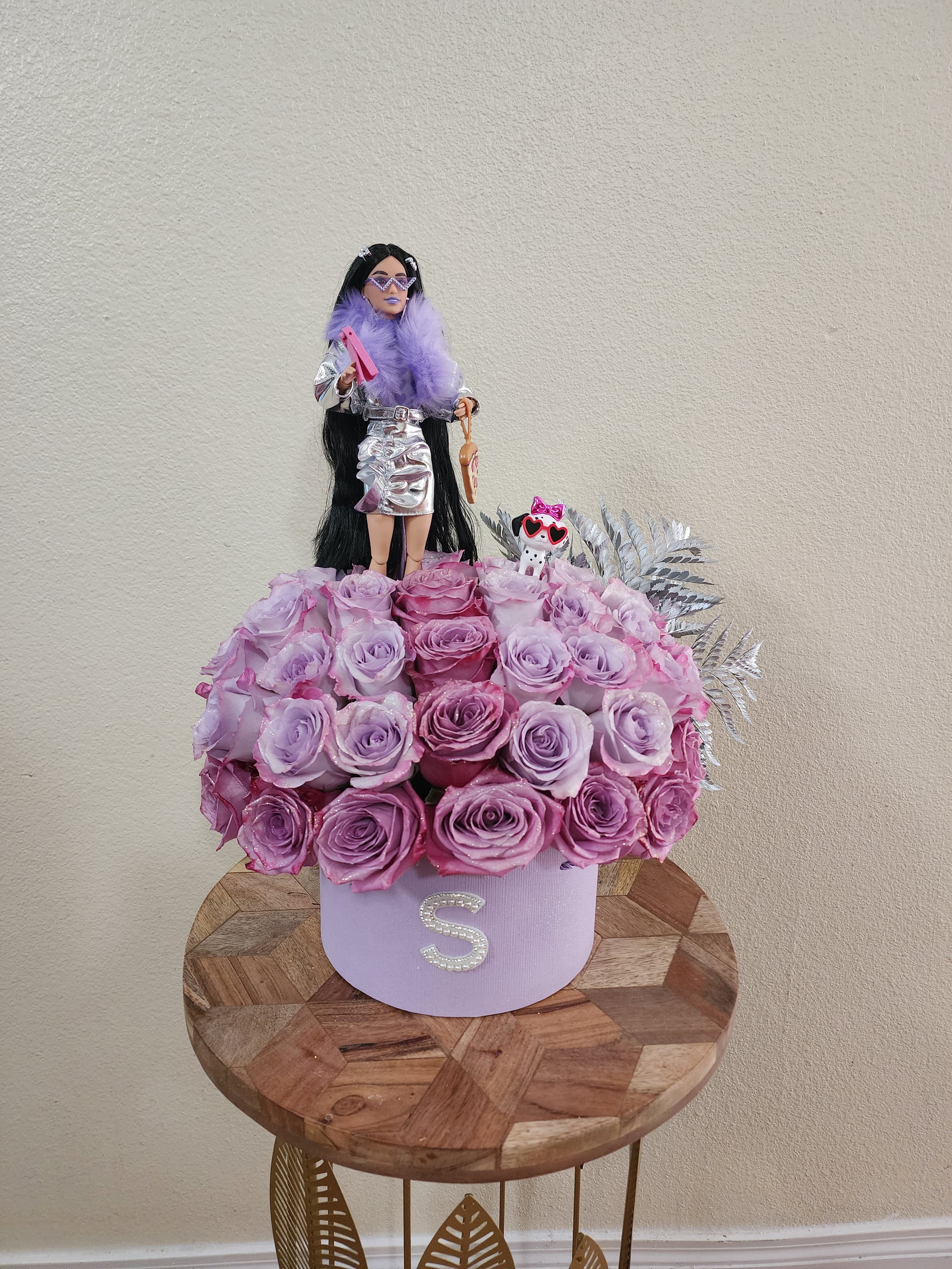 Lyla  - Elegant lavender-toned roses, beautifully presented with a fashion doll centerpiece for a touch of extra glam! Doll model may vary depending on availability.