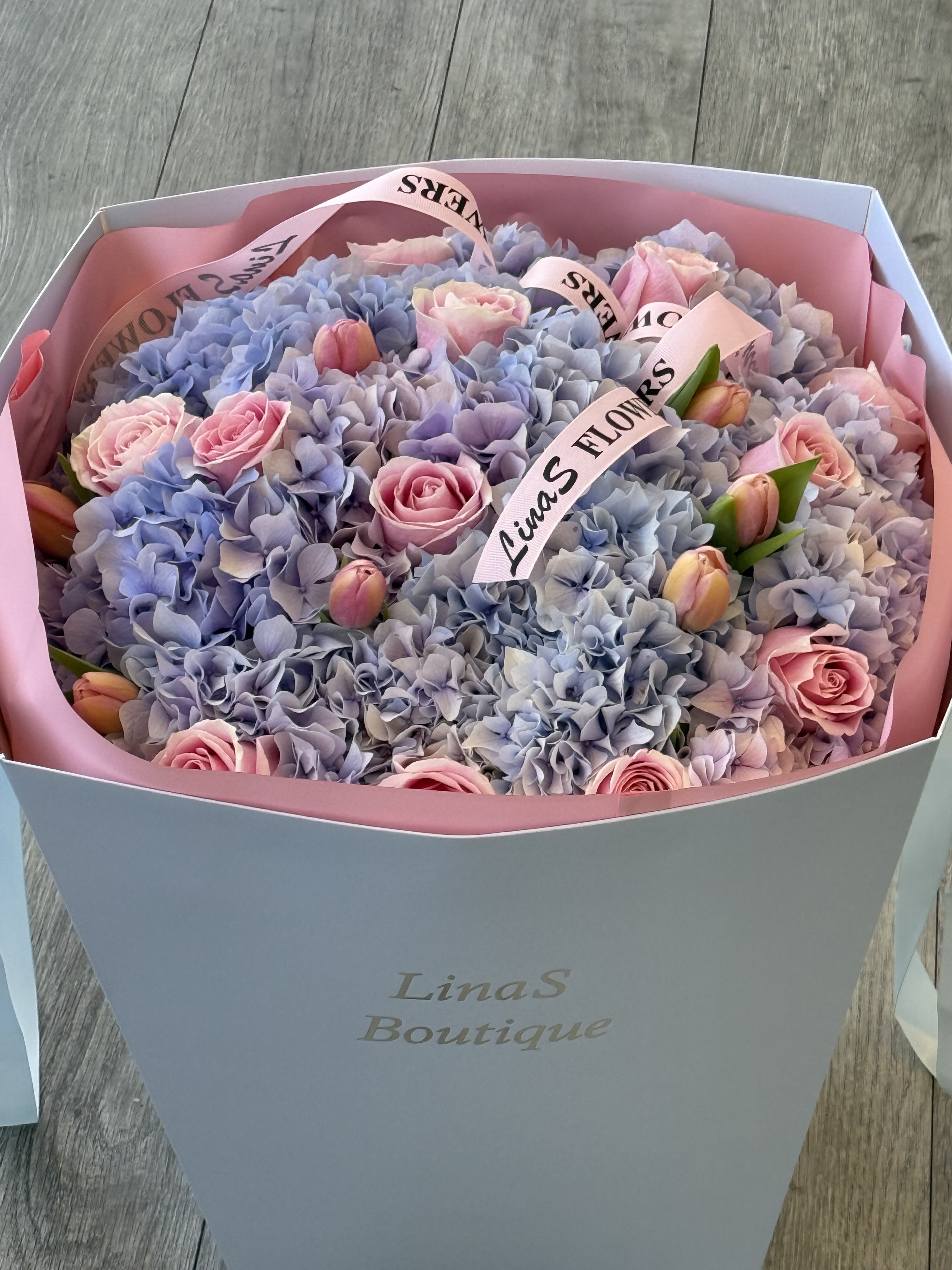 Maria Maria - Delicate mix of blue hydrangeas, pink tulips, pink roses, and purple roses—a harmonious blend of soft romance and vibrant charm.