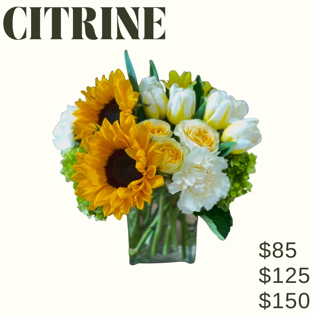 CITRINE CITRINE - A mix of yellow flowers arranged in a clear glass vase