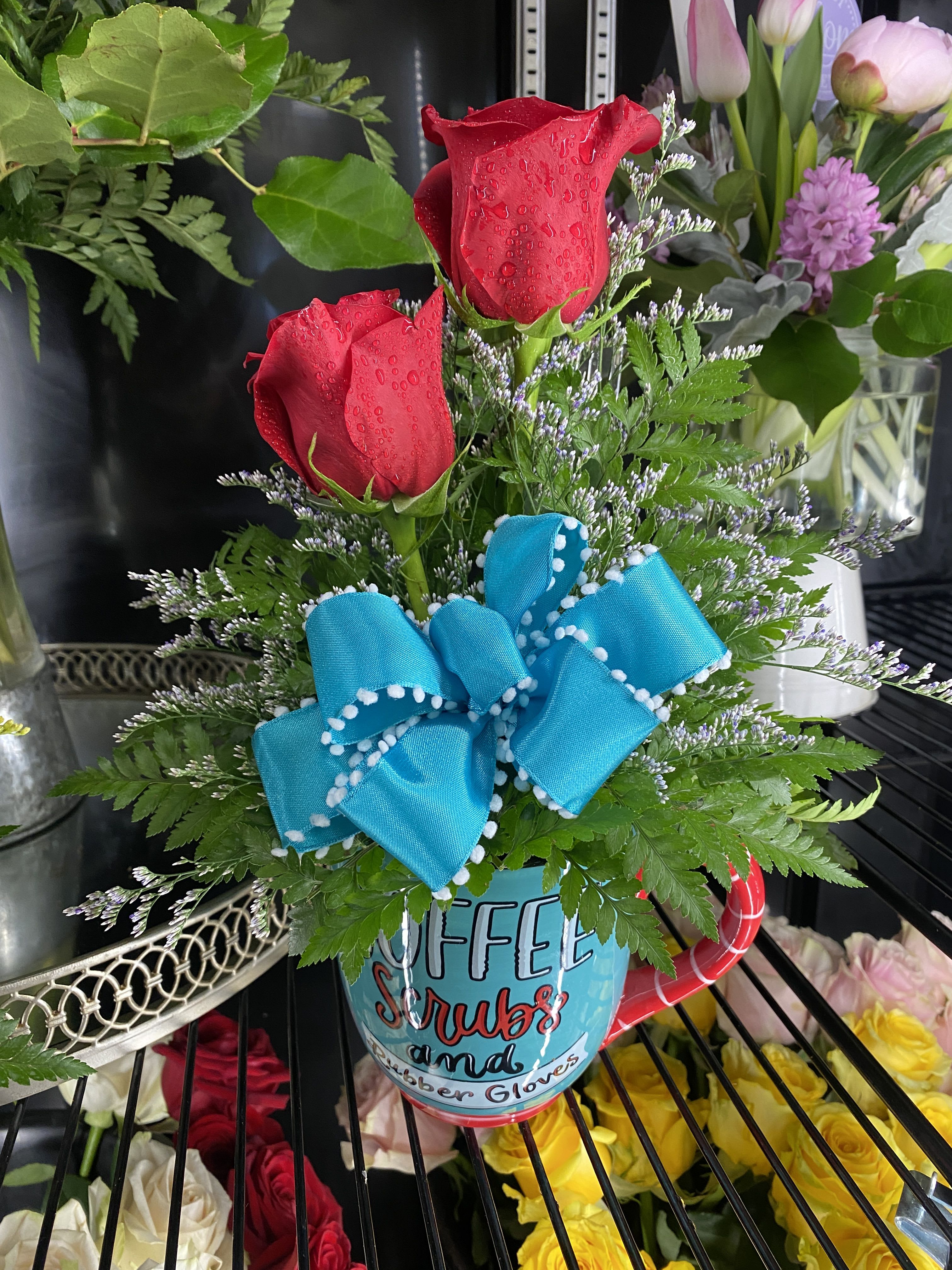Nurse Appreciation - Show your Nurse Appreciation with this cute mug arrangement! Bouquet includes: Red Roses, Leather Fern, Limonium, and a Blue Bow all arrangement in a cute nurses mug. 