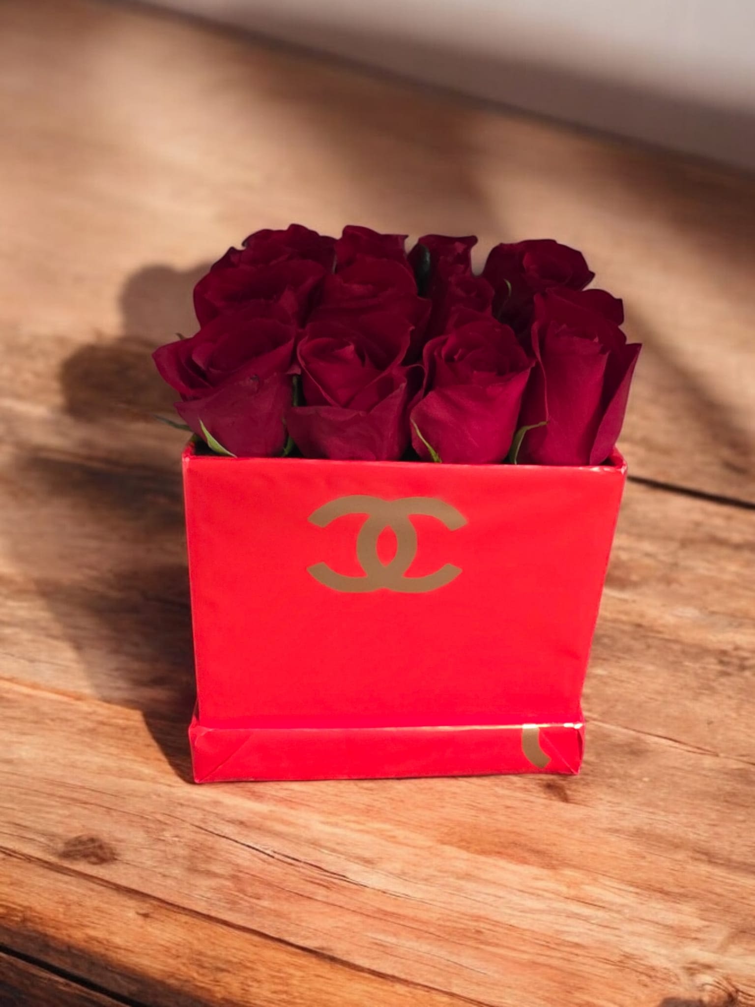 &quot;The Chanel Rose&quot; - El arreglo de Rosas rojas  dispuestas de forma compacta y simétrica dentro de una caja de regalo roja. Las rosas, de un color rojo intenso y aterciopelado, son las protagonistas del arreglo. Su color y la forma en que están dispuestas sugieren un estilo clásico