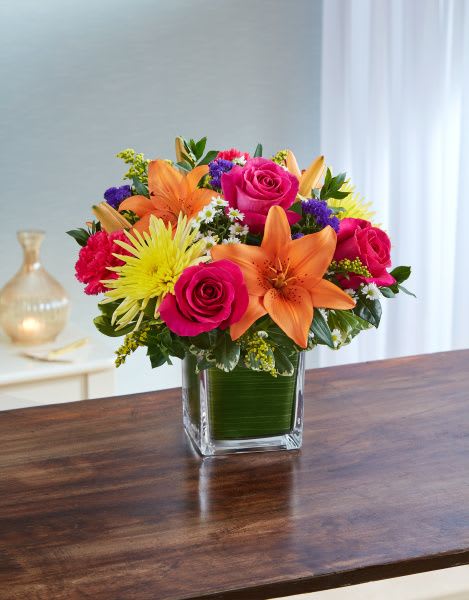 Healing Tears in Multicolor Healing Tears in Multicolor - Healing Tears in Multicolor is a beautiful mix of Colorful flowers in a leaf lined cube vase. This arrangement is available in 3 sizes and has roses in the Medium and Large Sizes only.