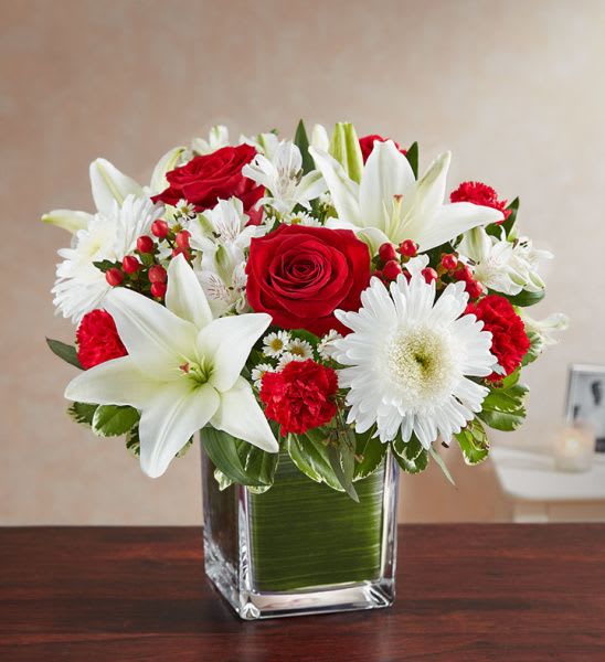 Healing Tears In Red and White Healing Tears In Red and White - Healing Tears in Red and White is a beautiful mix of Red and White flowers in a leaf lined cube vase. This arrangement is available in 3 sizes and has roses in the Medium and Large Sizes only.