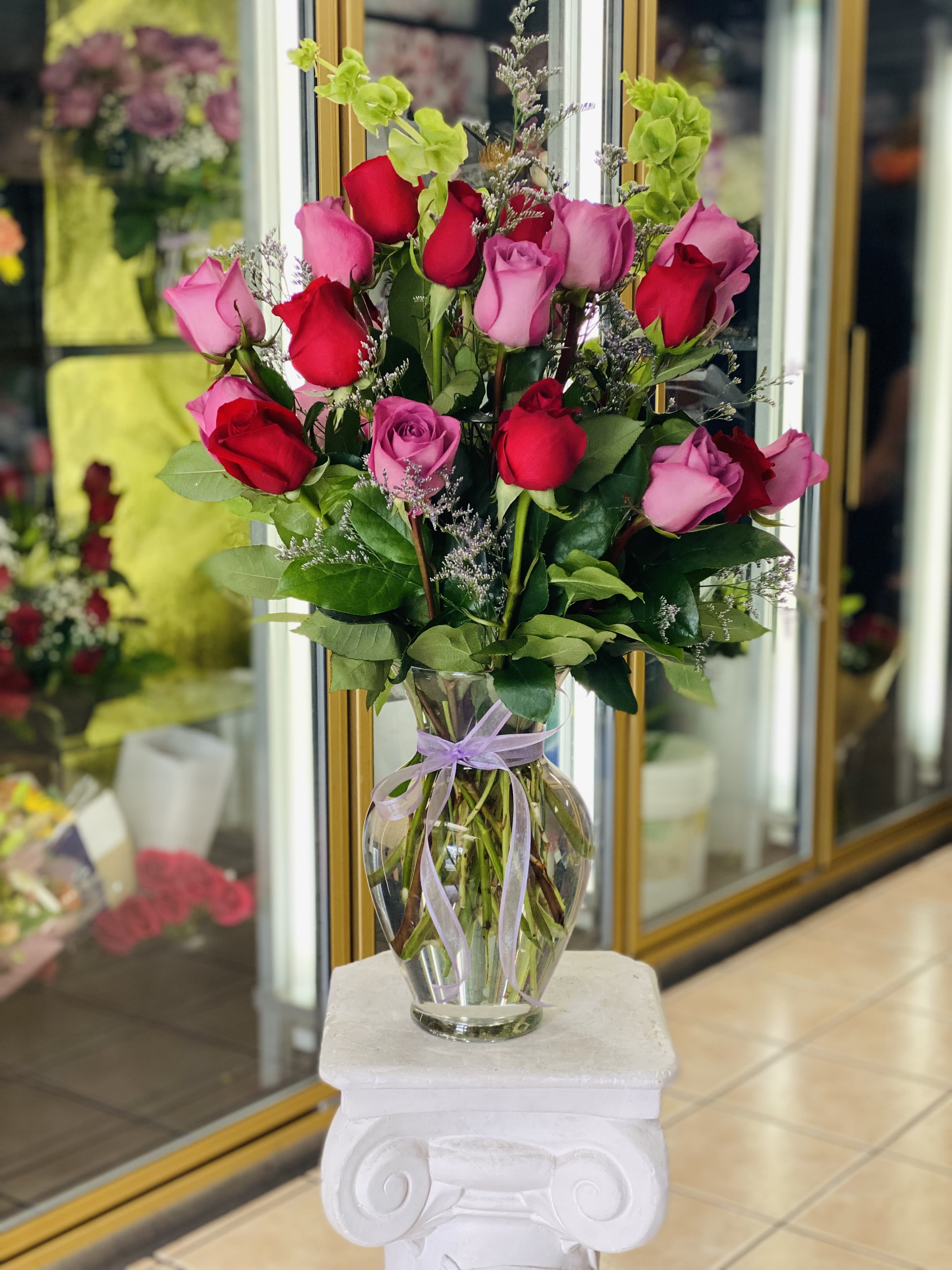Felicity Felicity - Twenty four tall roses red and purple, 360 view in a tall glass vase, garnished with ribbon and bells. Color roses are customizable.