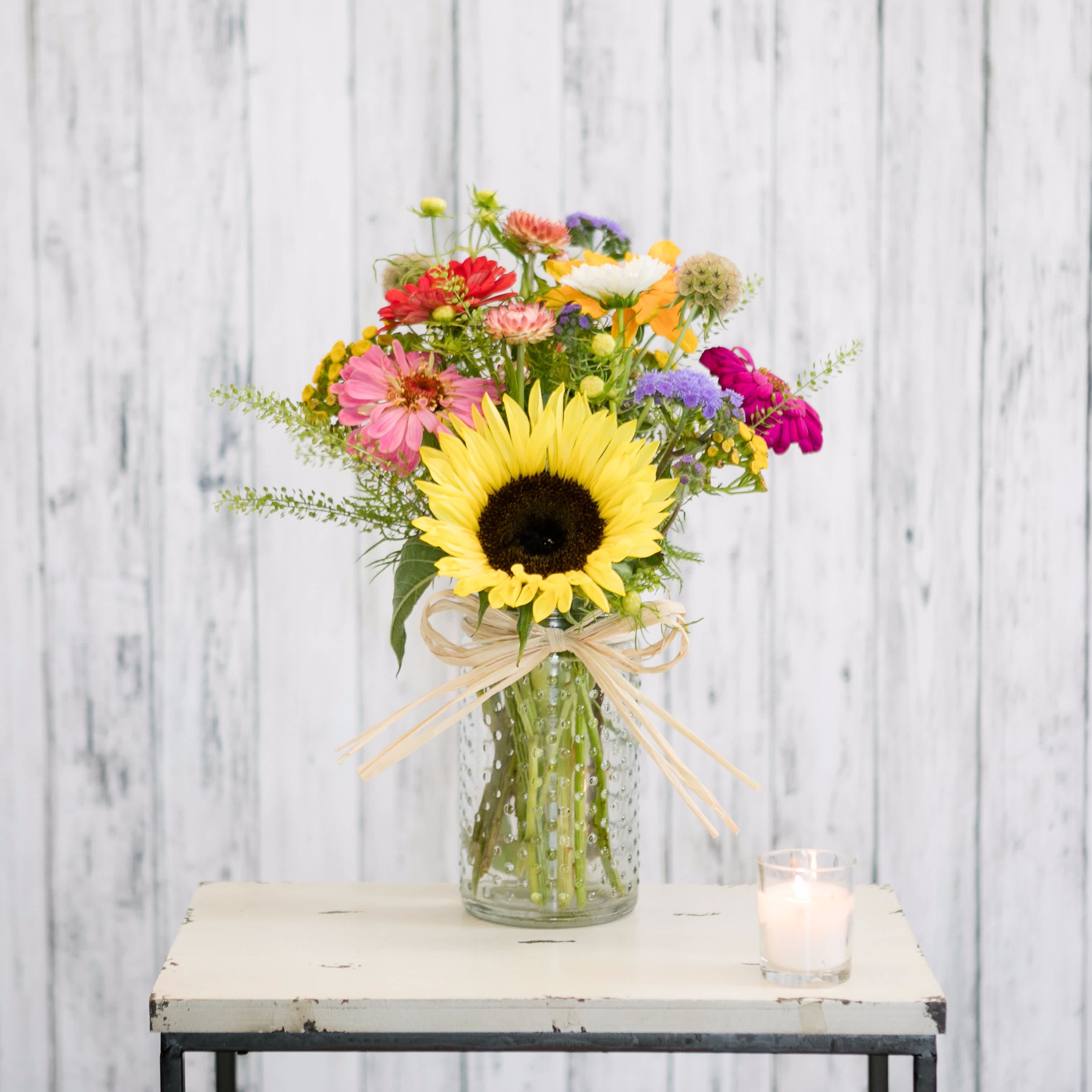 Local - A recycled hobnail vase tied with a natural raffia bow is filled with locally produced, sustainably grown blooms!  Each design is unique with every week providing its own unique blend of seasonal flowers and colors.  Get one while they last!  Approximate Dimensions: 14&quot; T X 8 &quot; W