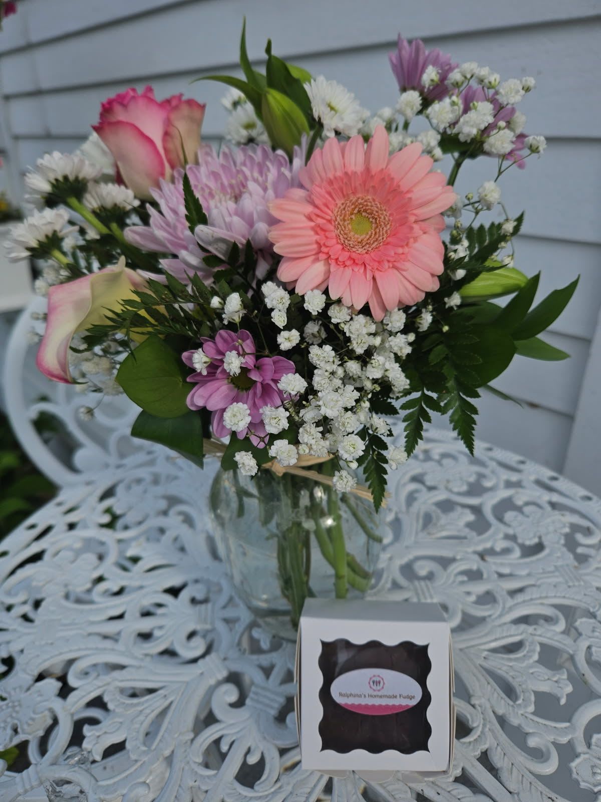 Pastel Delight Deal of the Day with Ralphina's Fudge - Pink roses, gerberas, calla lilies, purple daisies, lavender cushion poms, baby's breath and greens arranged in a vase with Ralphina's homemade fudge