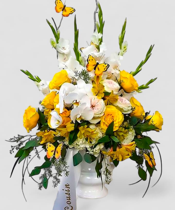 Celebration Of Life Yellow Bouquet Designer's Choice - Send this beautiful and thoughtful sympathy bouquet filled with lovely yellow blossoms of the day roses hydrangeas orchids and more arranged in a tall modern white vessel vase. Perfect to send to the service. Always made extra special and unique each and every time. Send them your deepest condolences.