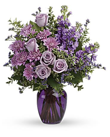 Together at Twilight - The perfect pick for the purple lover in your life! This dramatic arrangement includes lavender roses, lavender stock, lavender cushion spray chrysanthemums, lavender limonium, oregonia and lemon leaf. Delivered in a purple glass vase. Orientation: All-Around