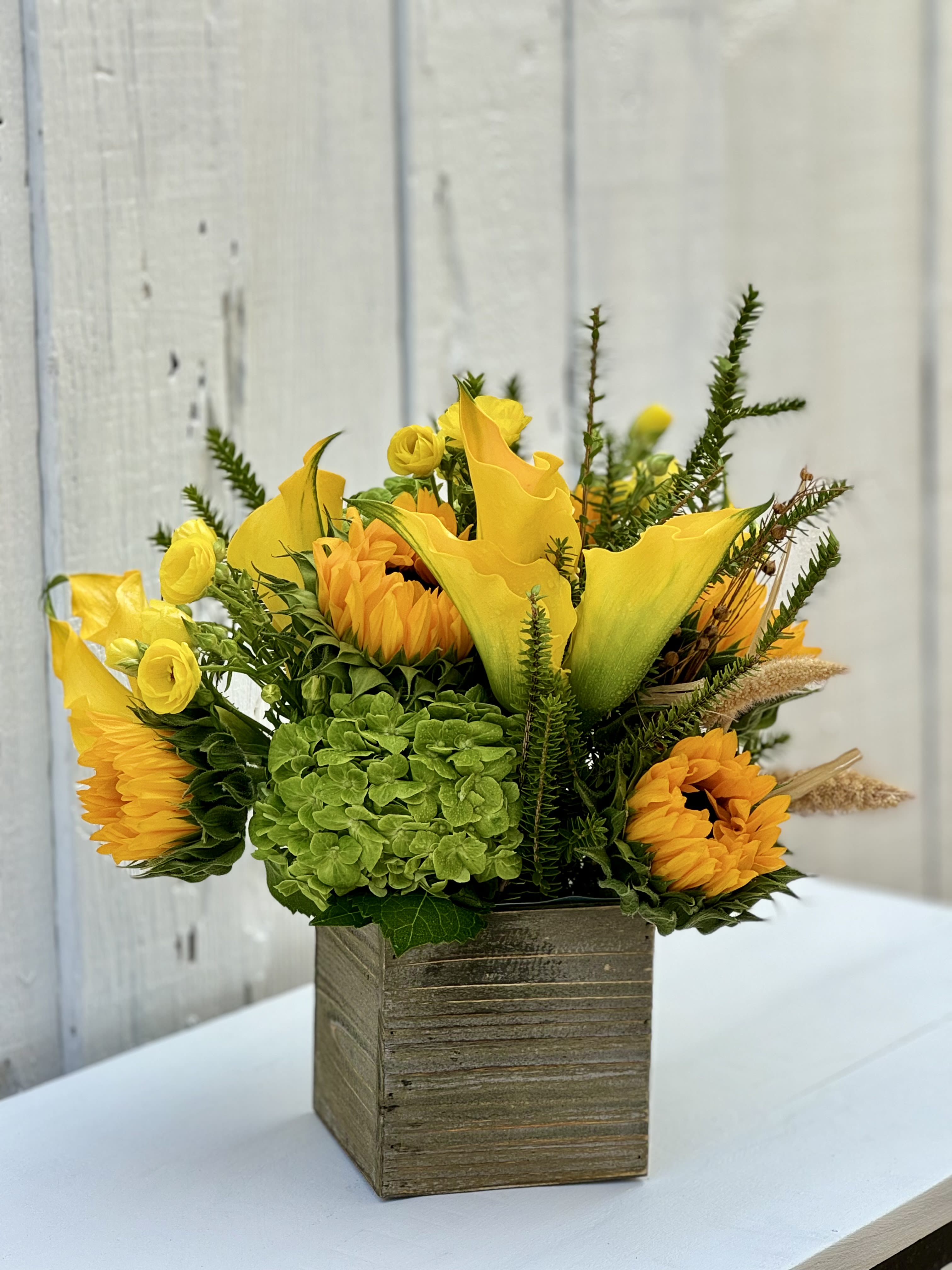 SOUTH BAY SUNSET - A very sweet and bright yellow design with pretty sunflowers, calla Lilly’s, butterfly ranunculous, hydrangeas…. It comes designed in a cute 5x5 wooden box. 