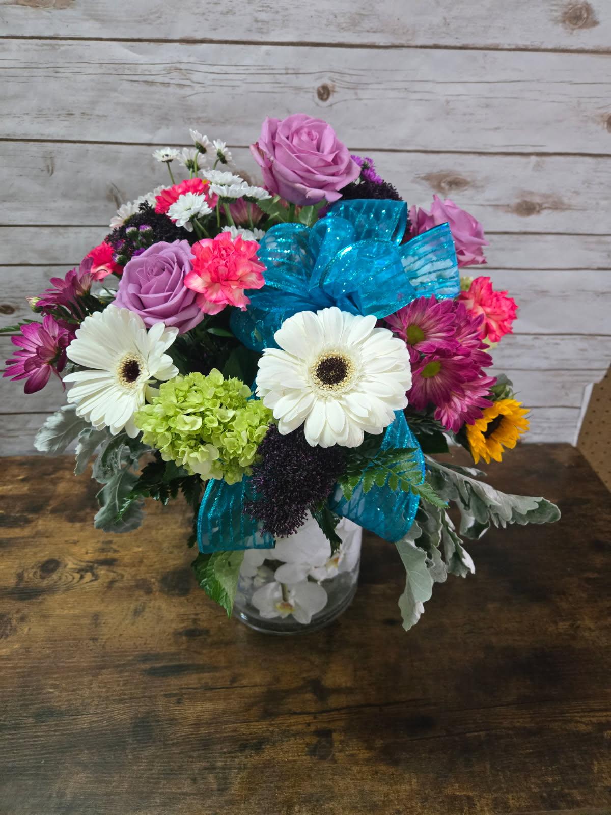 Cheery Wishes Cheery Wishes - Cheery and bright vase of beauty. Includes roses, gerbera daisies, small hydrangeas, mini carnations and more. Looking for a variety...here it is.