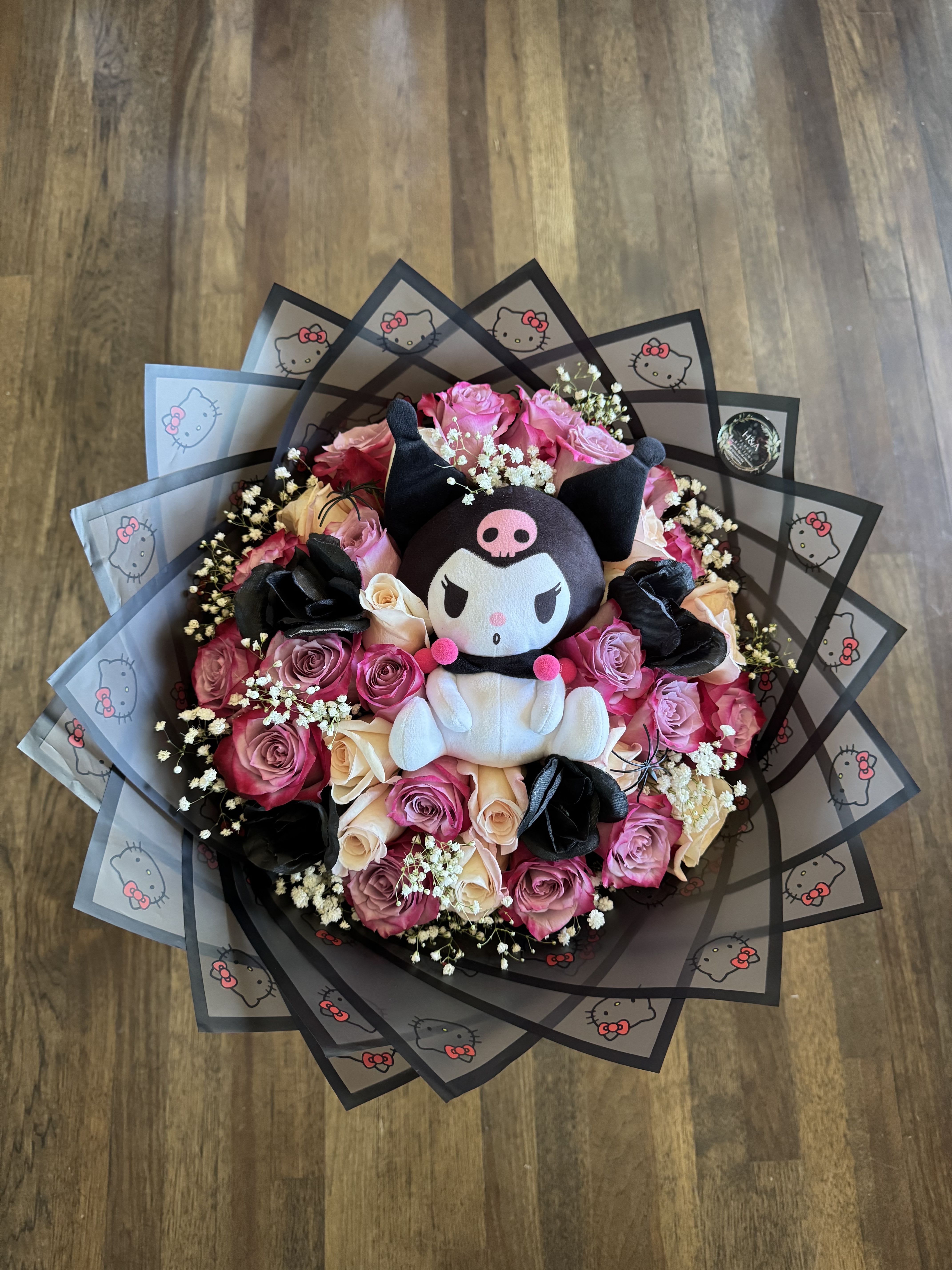 Kuromi bouquet  - Kuromi plush as the main protagonist of this beautiful bouquet made up of purple and white roses, black rose details, touches of baby's breath and decorative details black hello kitty wrap. Available every day  Peluche de Kuromi como protagonista principal de este precioso ramo conformado por rosas moradas y blancas, detalles de rosas negras, toques de aliento de bebe y detalles decorativos envoltura color negra de hello kitty . Disponible todos los dias.