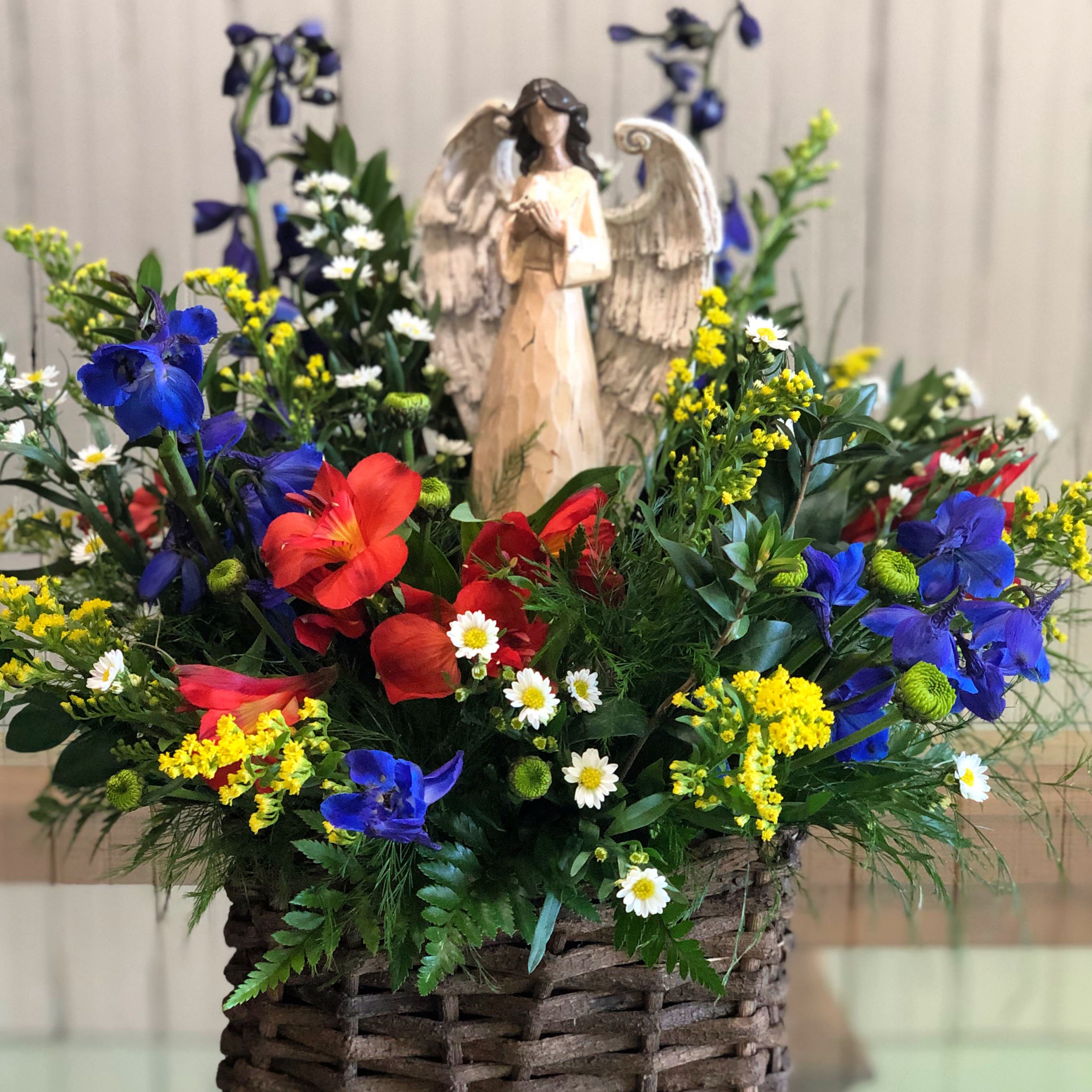Garden Angel - A lovely mix of wildflowers arranged in a basket with an angel in the middle of it for a cherished keepsake. ****We will try our best to match the flowers in the picture, but there may be times when we substitute flowers.  We will always try to make it have the same look and feel as the original.