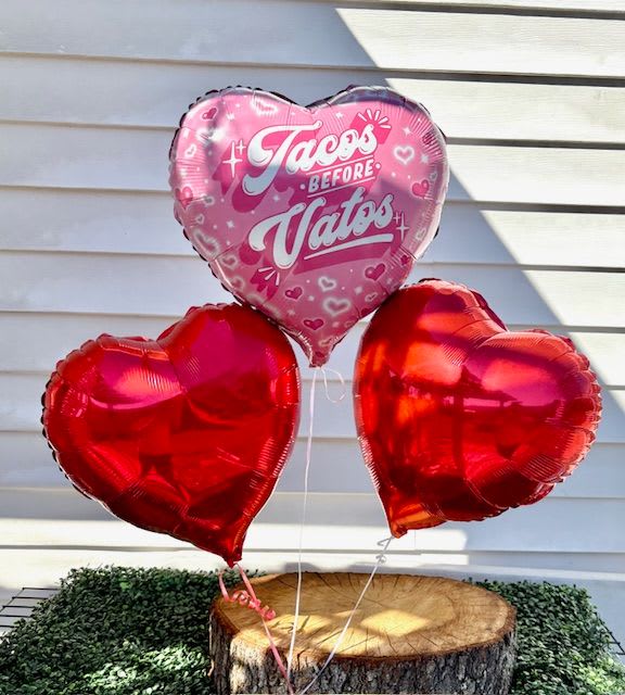 Tacos before Vatos Balloon Bouquet  - This bold yet playful balloon bouquet floats with flair—pink heart shaped, like laughter caught mid-air. It's crafted from high-quality mylar with a sheen that catches the light and tosses back sparkles in return.  Centered proudly in curvy, whimsical script are the words: “Tacos Before Vatos.” The lettering is a stylish blend of pastel pink and white, outlined in soft white for a pop of contrast, like crema on a perfect street taco.   Tied at the bottom is a satin ribbon—maybe fuchsia or teal—those cascades down like a playful wink. This balloon isn’t just cheeky; it’s a celebration of self-love, laughter, and bold priorities with a delicious twist.  Perfect for Galentine’s Day, birthdays, girls’ night in, or anytime you need a reminder that tacos (and self-worth) come first.   Want us to pair it with a cute message or card idea? Try this, Life’s too short to chase drama when tacos are calling. You deserve the extra guac, the crispy shell, and all the spicy love in the world. Here’s to choosing joy, carbs, and YOU—always!  All three ballons included. 